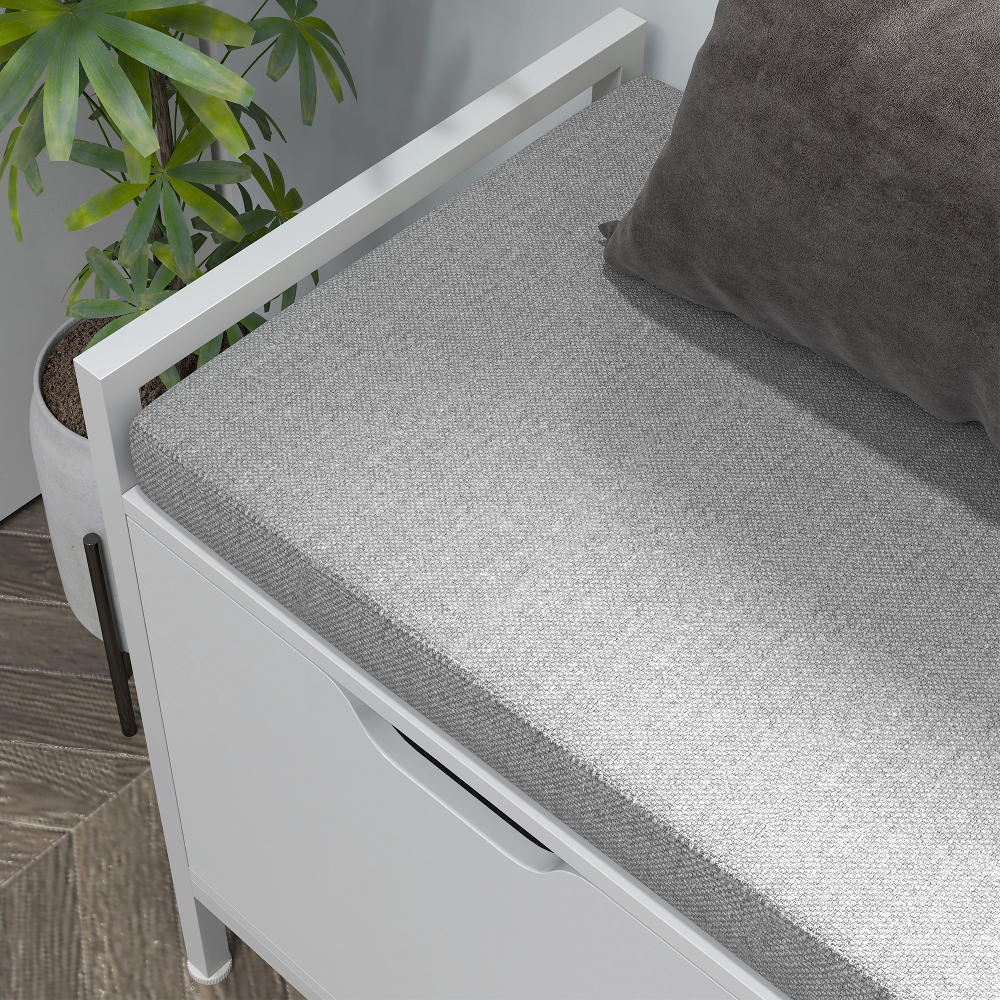 Banco blanco con cojín gris y almohada oscura, junto a una planta.