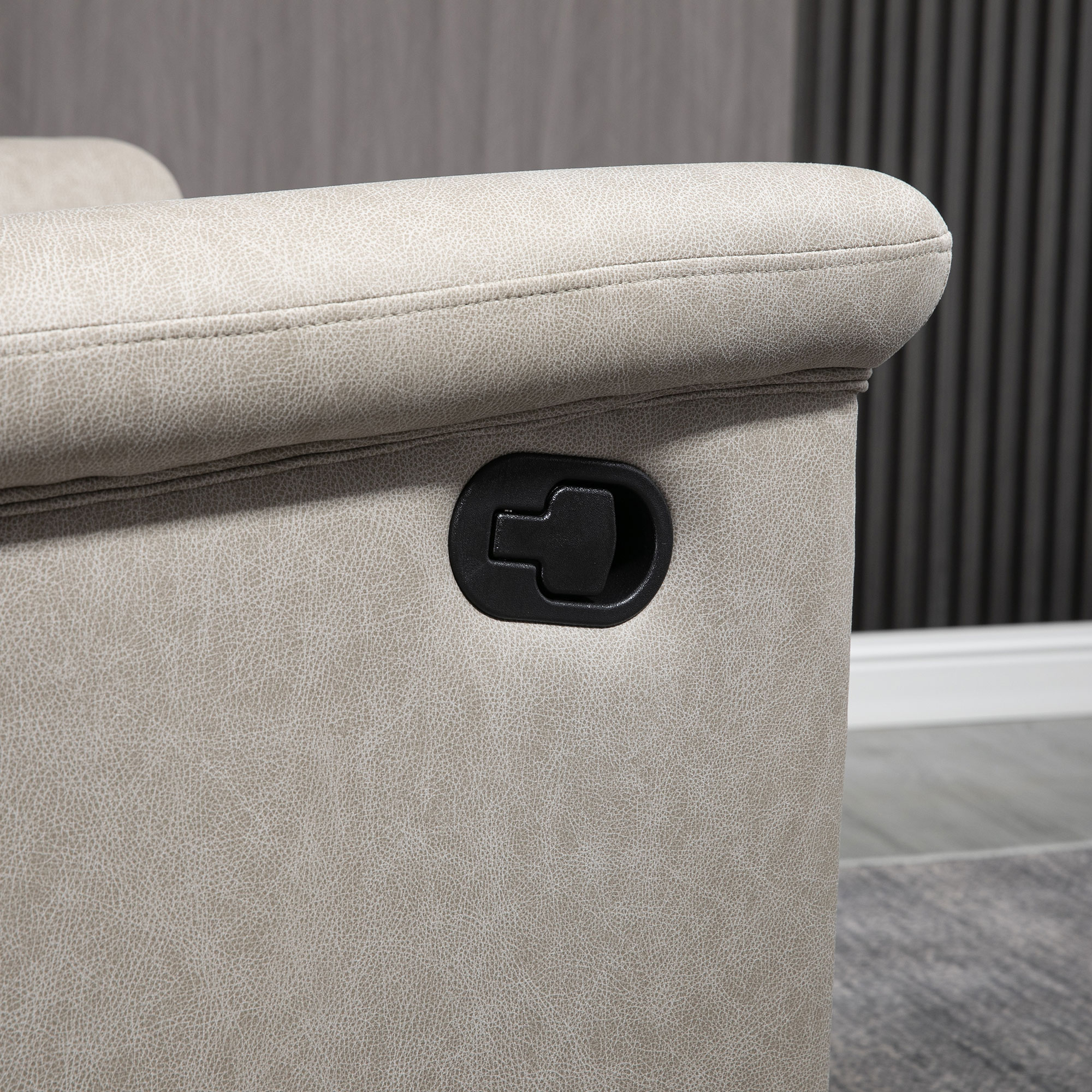 Un sillón color crema con palanca negra para ajustar.