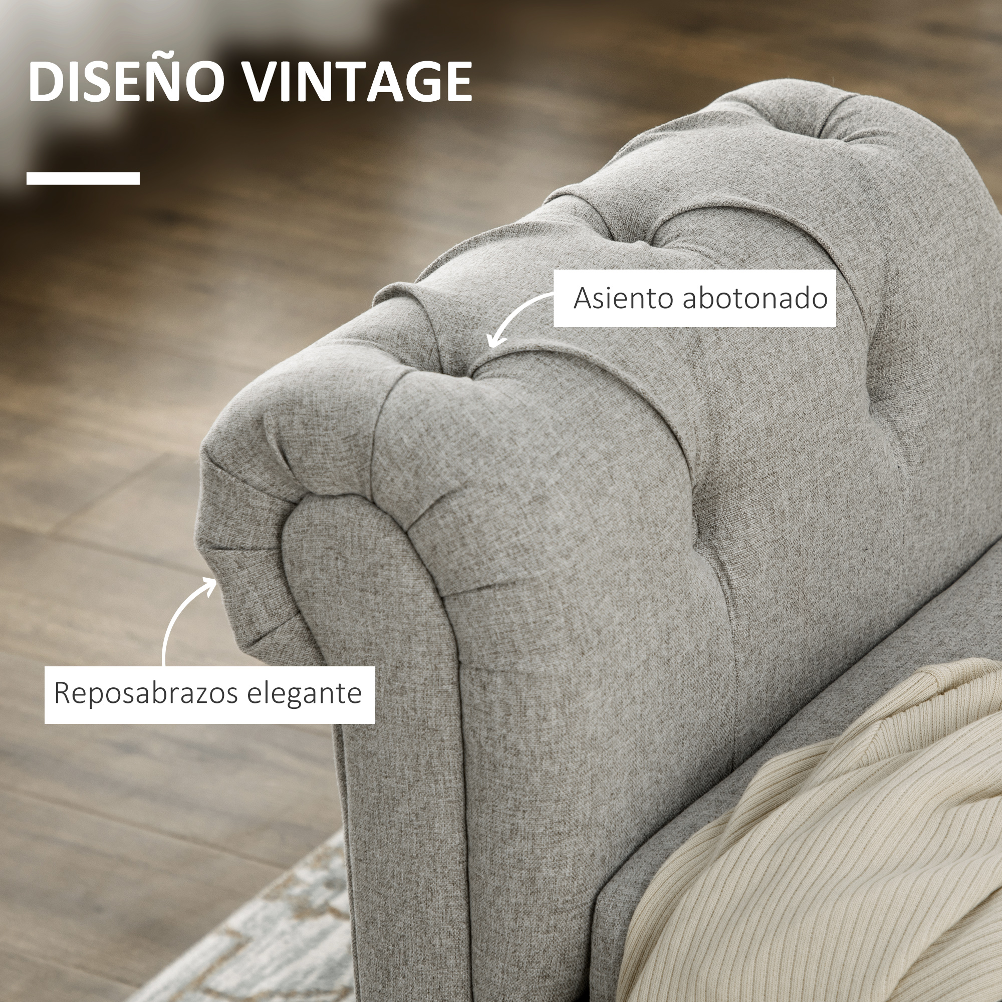 Sillón gris con capitoné y detalle elegante en el reposabrazos.