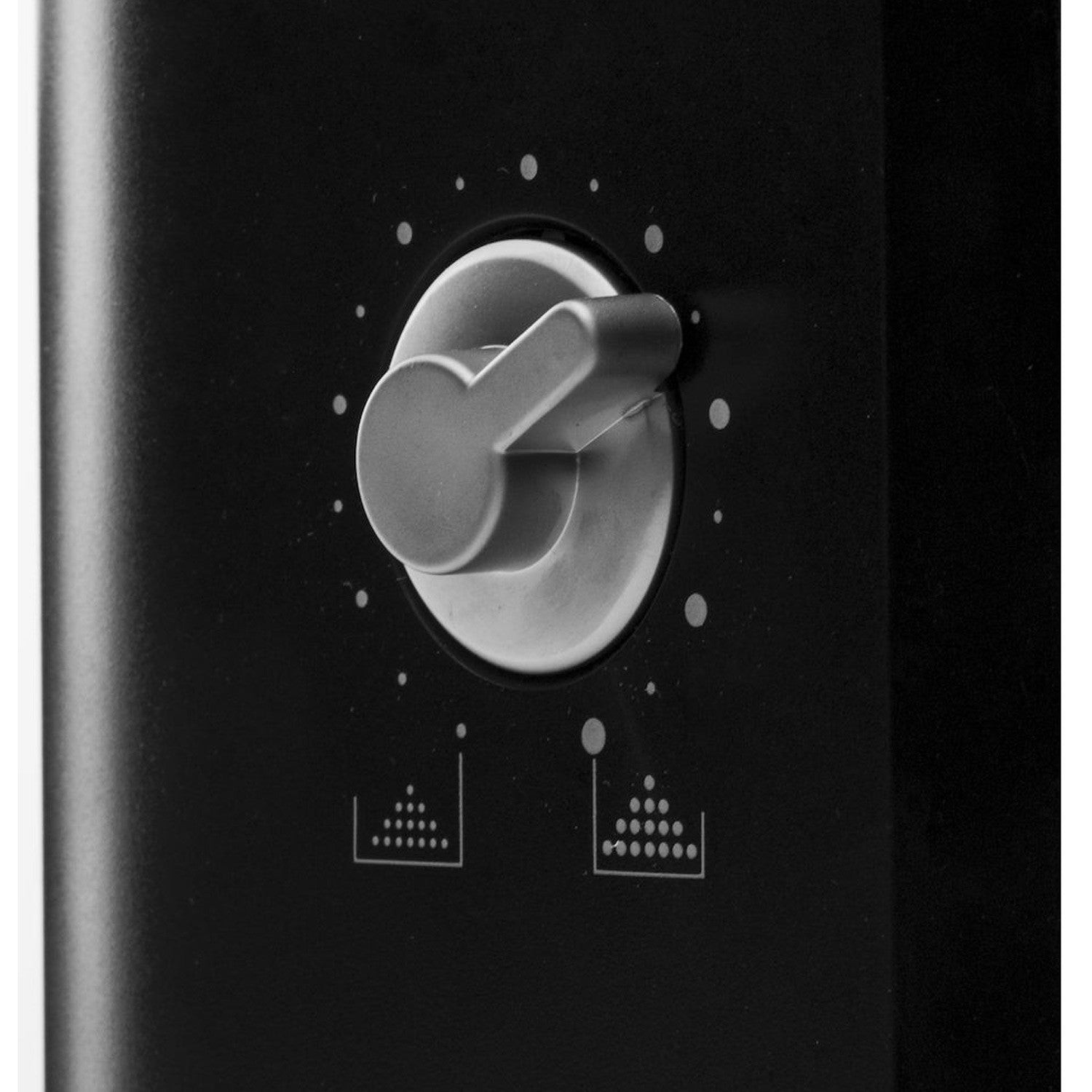 Gray rotary knob on a black panel with icons for mist and fine spray.