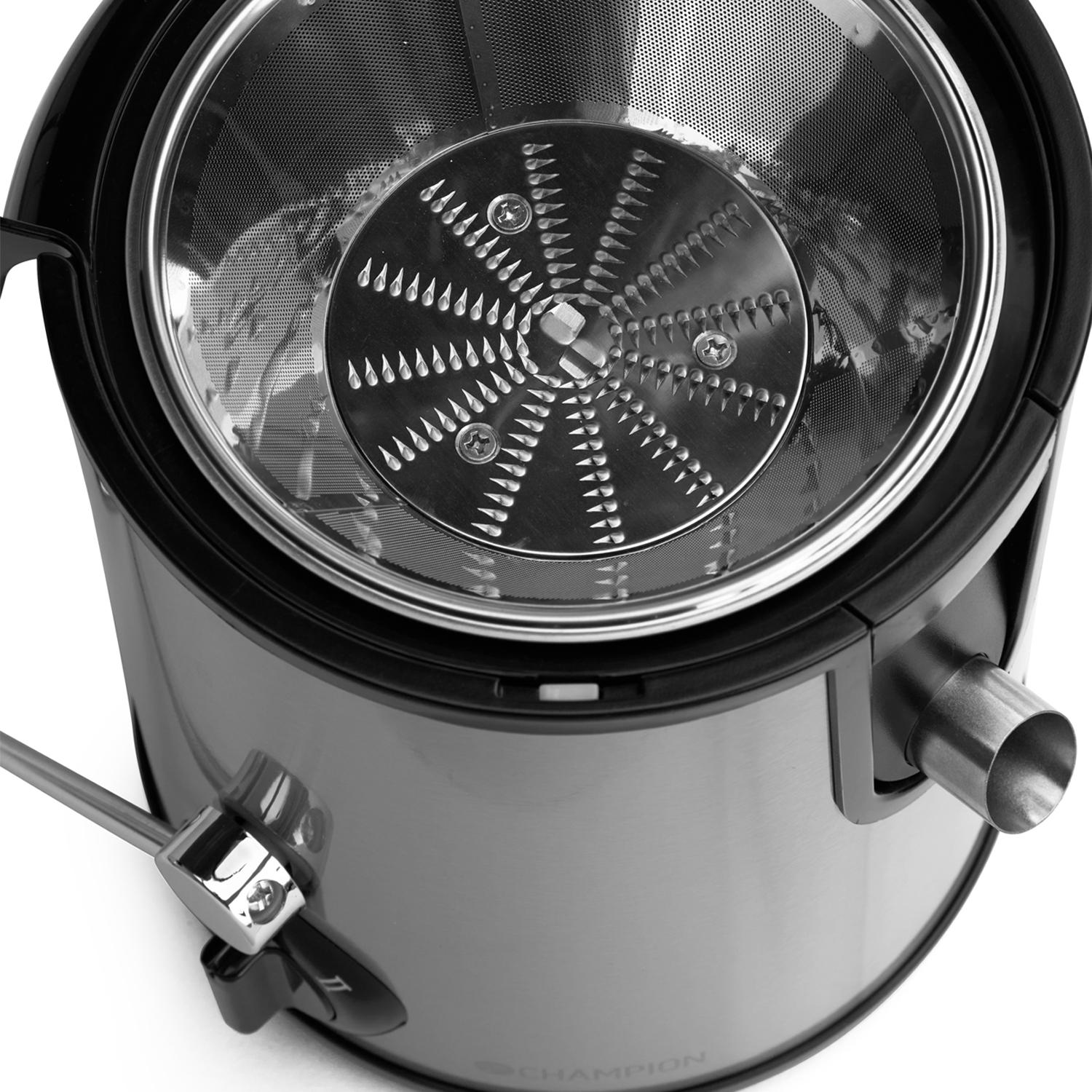 Close-up of a juicer's interior: a metal blade and strainer with a spout on the side.