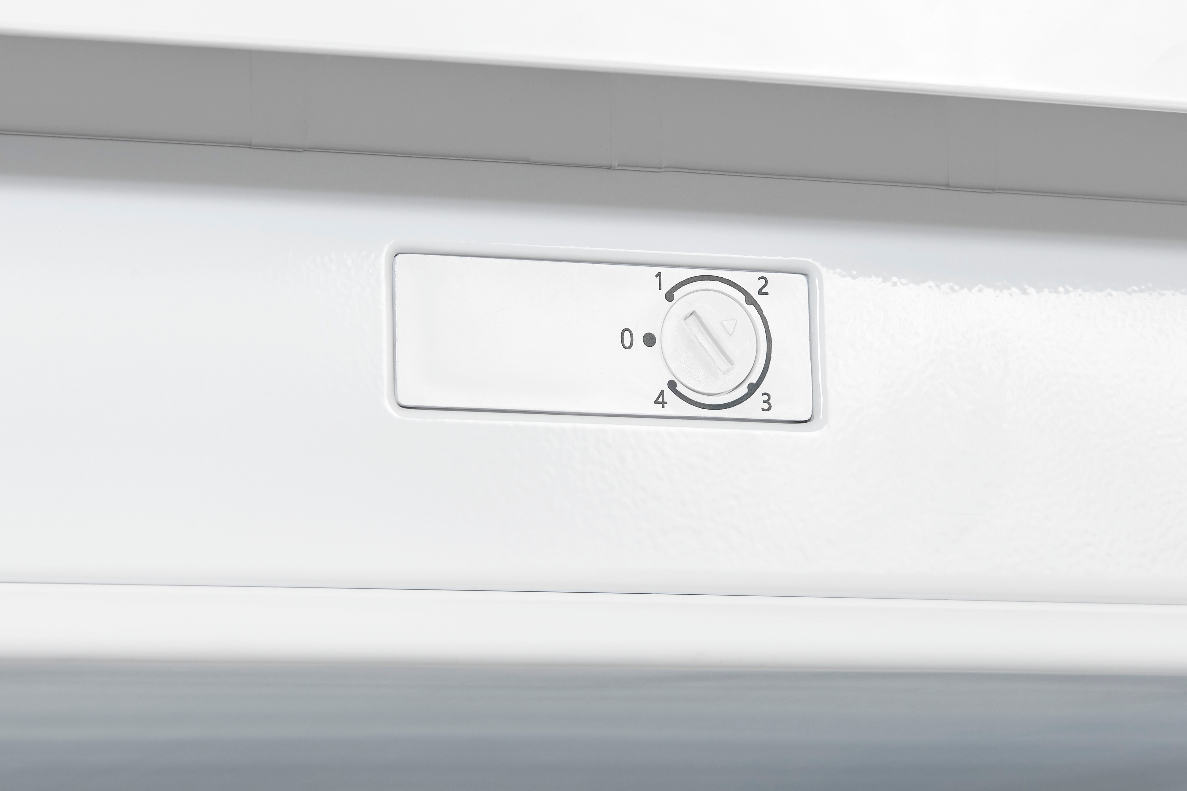 Un dial blanco con números 0-4 en un panel de control blanco.