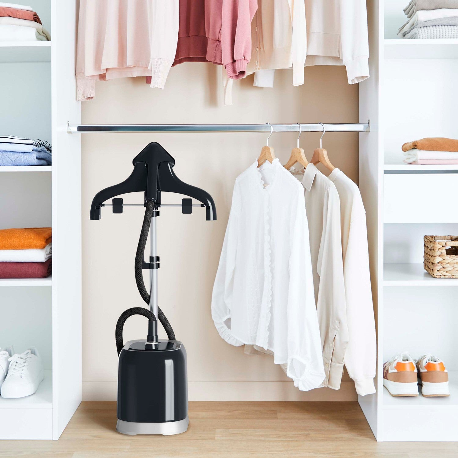 A black garment steamer stands in an open white closet with clothes.