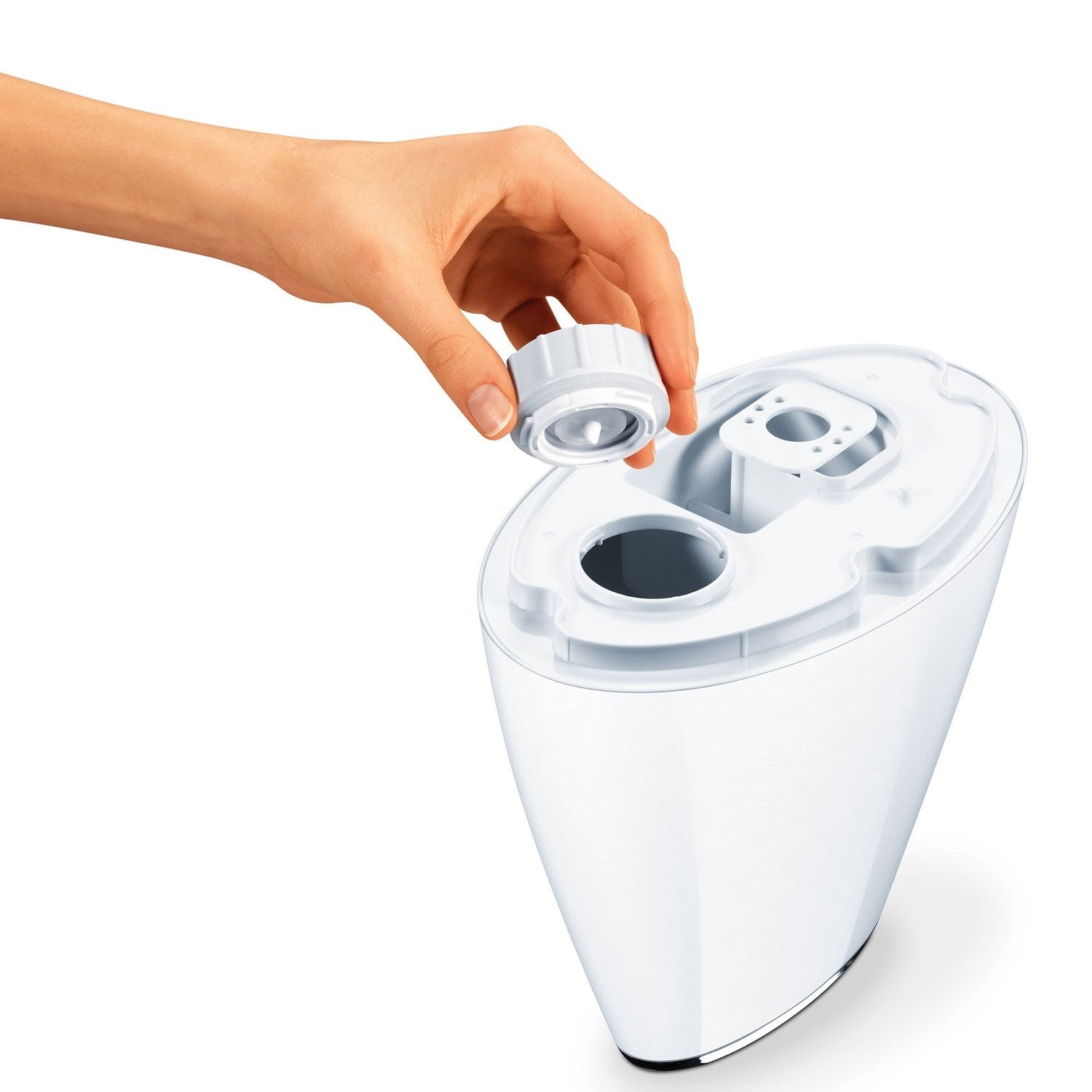 A hand holds a white cap over a white humidifier.
