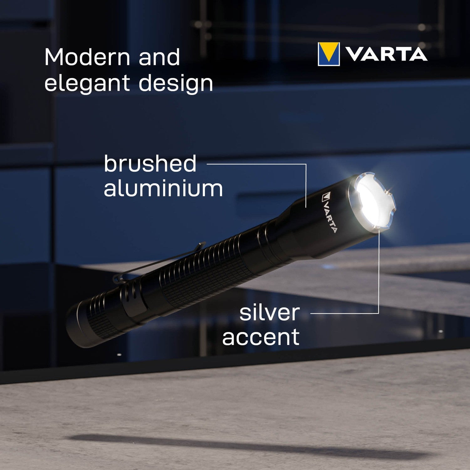 Een Varta zaklamp van geborsteld aluminium schijnt fel op een betonnen vloer.