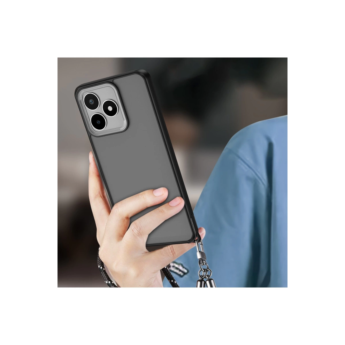 Bir el, üç kameralı gri akıllı telefonu ve takılı kordonu tutuyor.