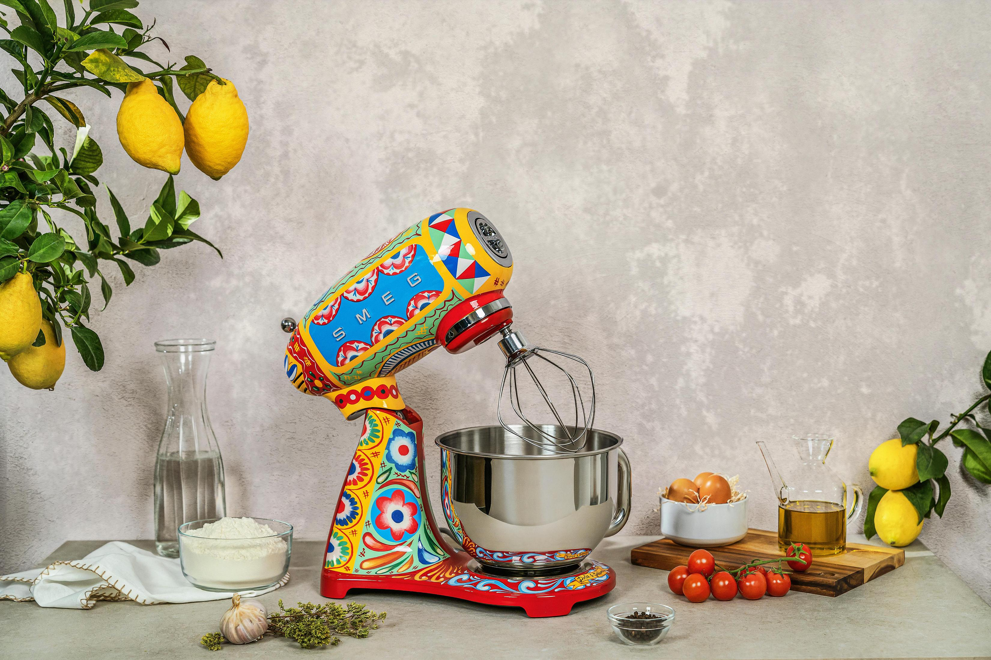 Un colorido robot de cocina con limones, huevos, tomates y aceite de oliva.