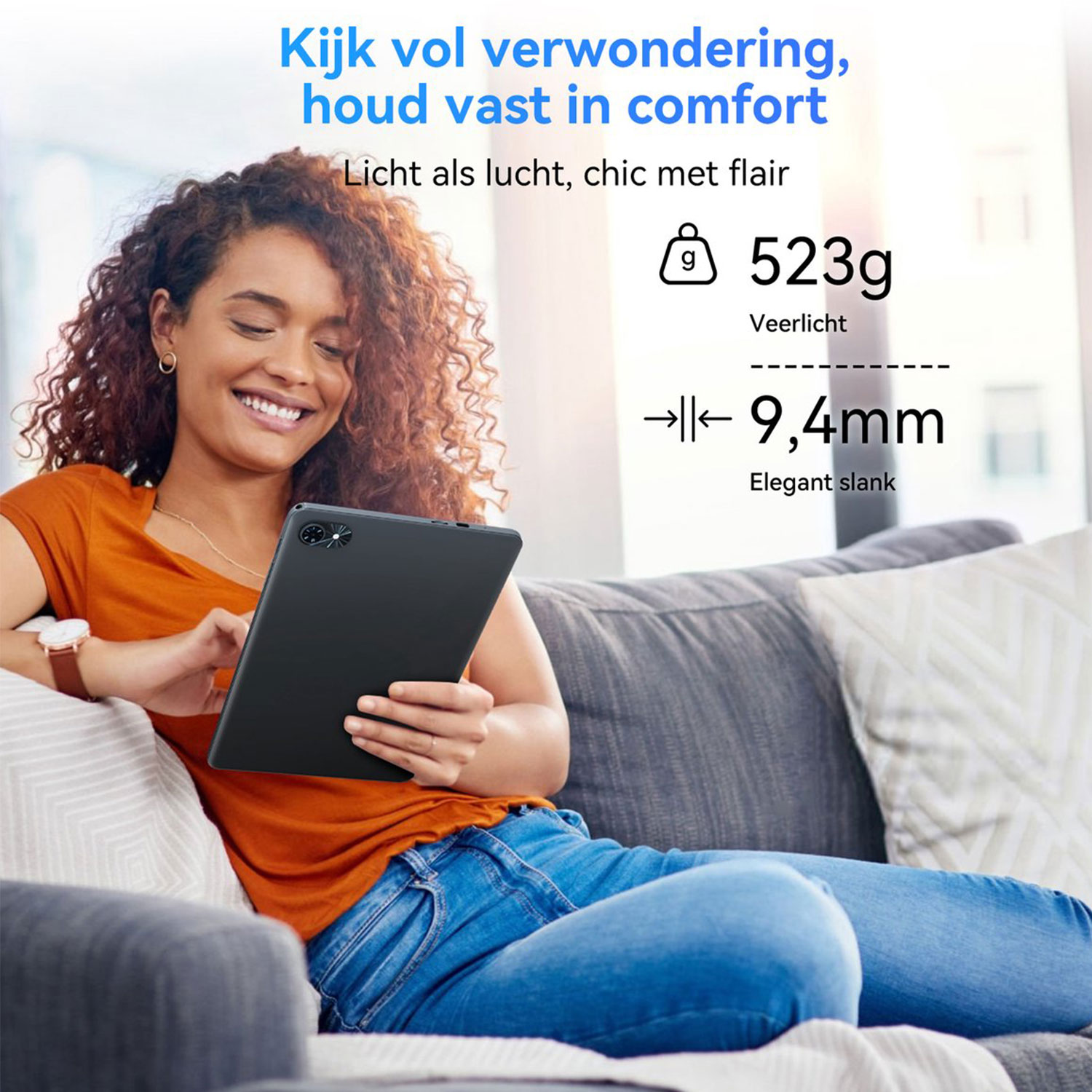 Een vrouw zit op een bank en houdt een zwarte tablet vast. Hij weegt 523g en is 9,4 mm dik.