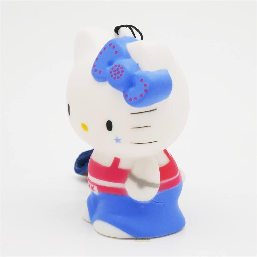 Eine weiße Hello Kitty Figur mit blauem Schleifenband, rot-weiß gestreiftem Oberteil und blauer Hose.