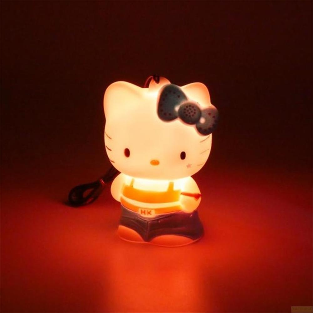 Eine leuchtende Hello Kitty Lampe in Jeans und Latzhose mit blauem Schleifchen.