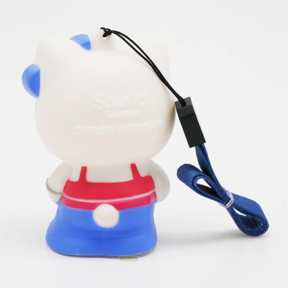 Eine weiße Hello Kitty Spielzeugfigur mit blauen Ohren und roter Latzhose über blauer Hose.