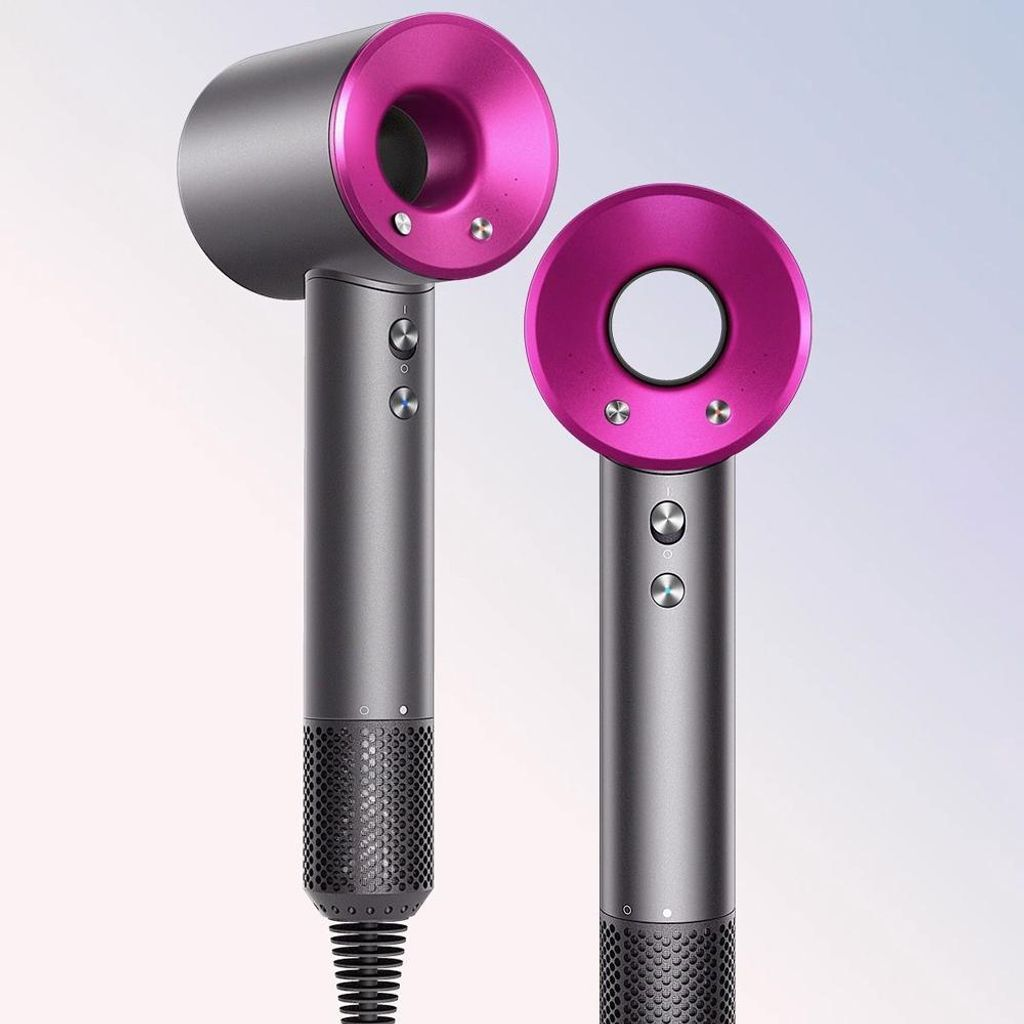 Zwei graue Haartrockner mit pinken Ringen und silbernen Schrauben auf hellem Hintergrund.