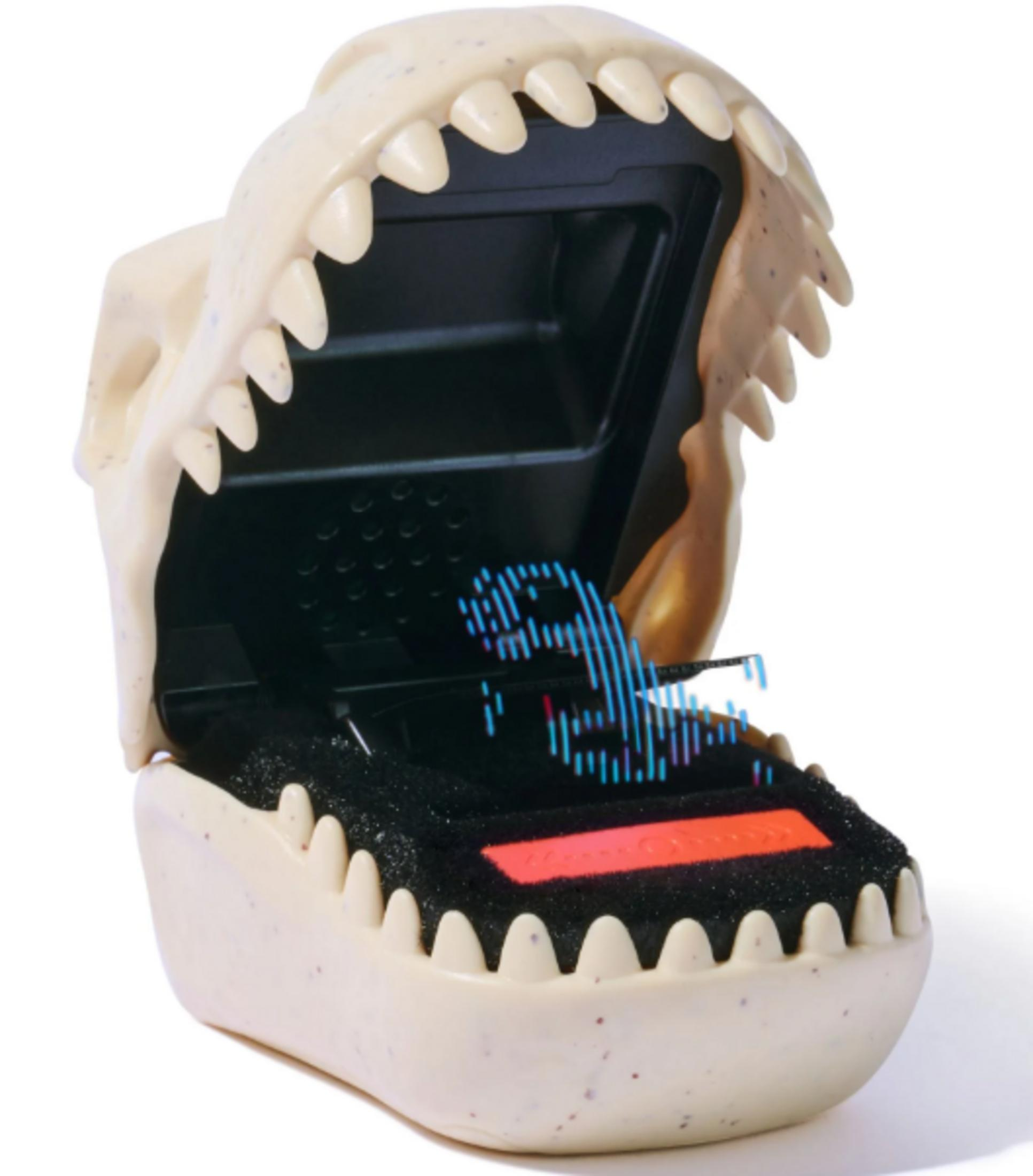 Un juguete con forma de mandíbula abierta con dientes que muestra una imagen digital.