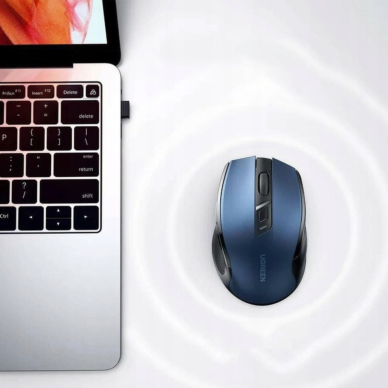 Niebieska mysz UGREEN obok klawiatury laptopa z kluczem USB.