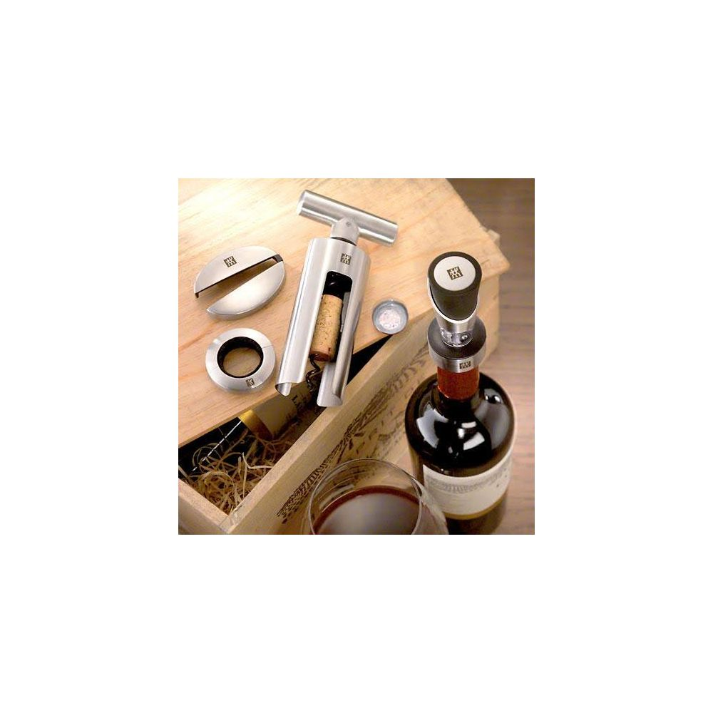 Cavatappi, tagliafoil, tappo e bicchiere di vino rosso in cassa legno.
