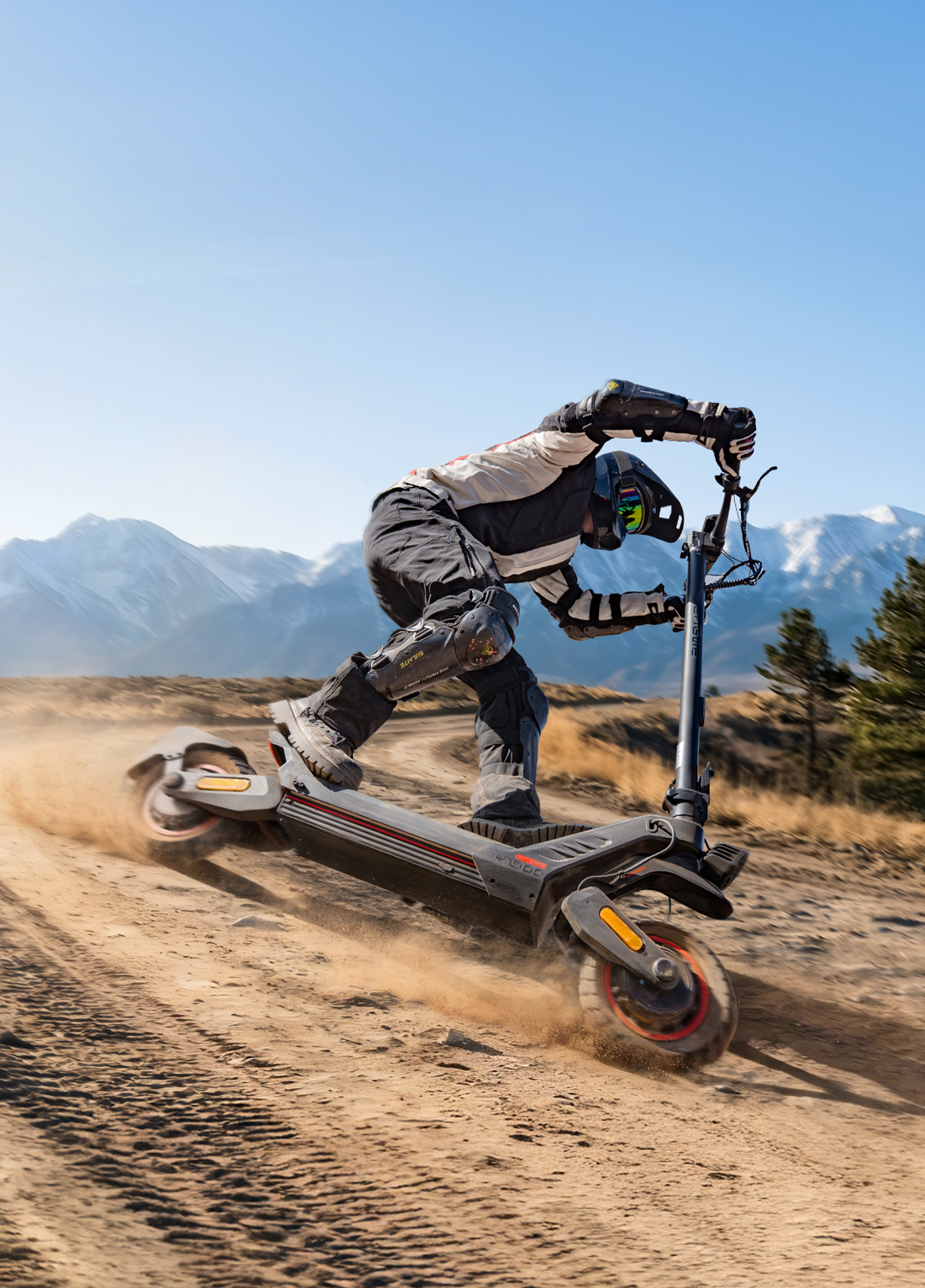 Ein Mann auf einem E-Scooter fährt auf einem staubigen Weg in den Bergen.