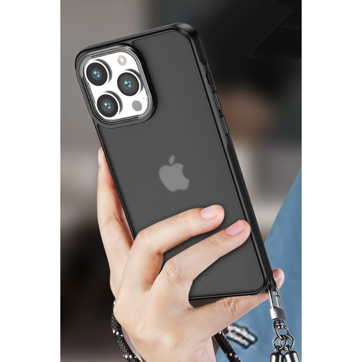 Bir el, dört kameralı ve Apple logolu siyah bir iPhone tutuyor.