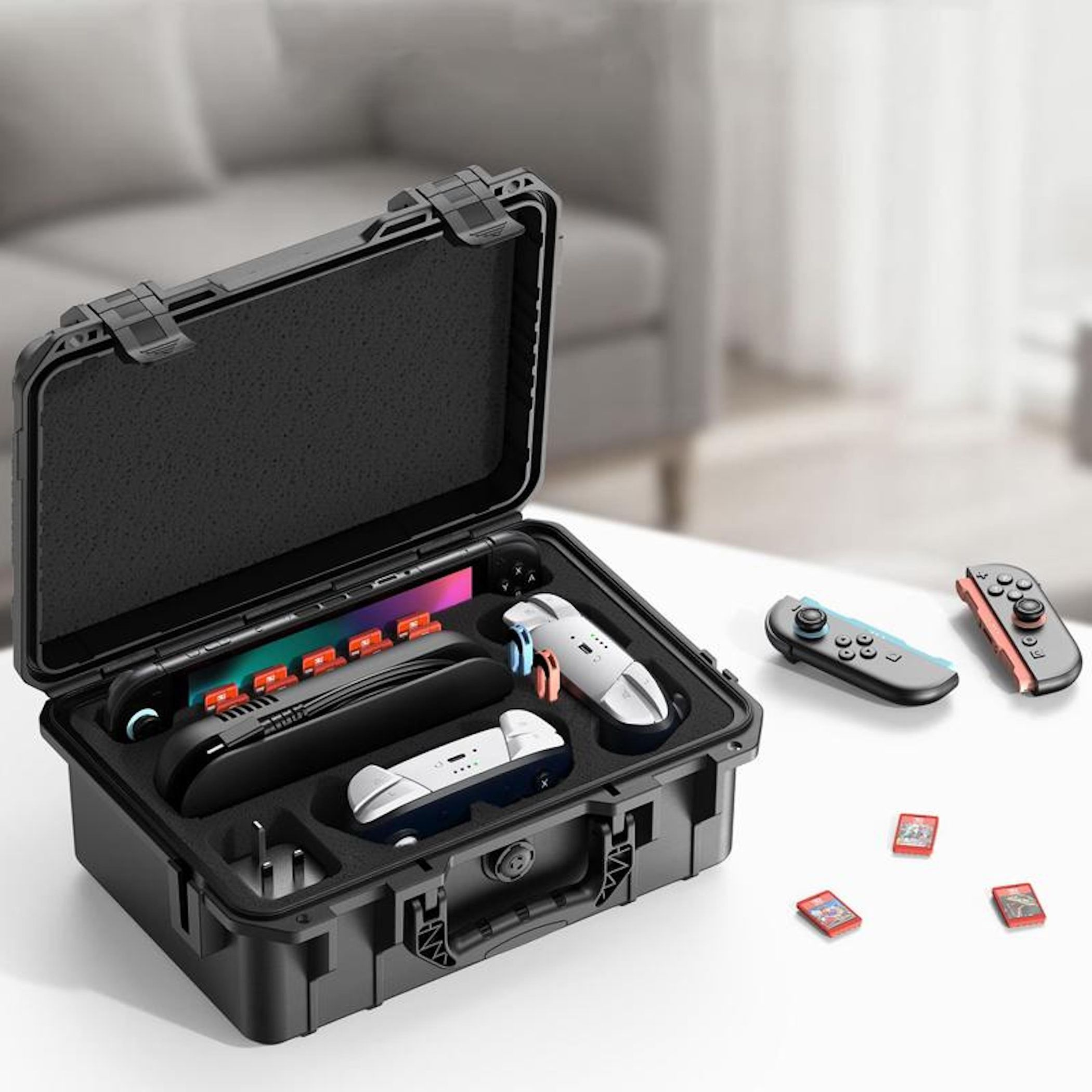 Un estuche negro abierto con accesorios de consola de videojuegos, dos Joy-Cons y tres tarjetas de juego.