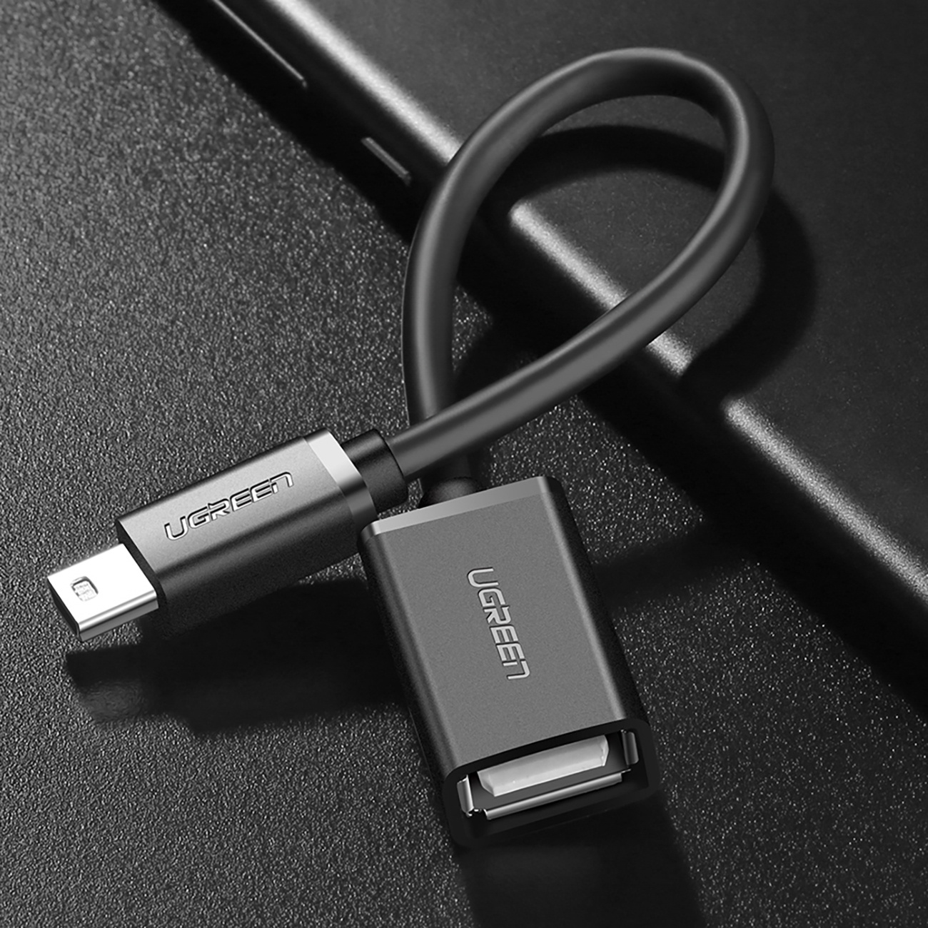 Adapter UGREEN z portami micro USB i USB-A na ciemnej, teksturowanej powierzchni.