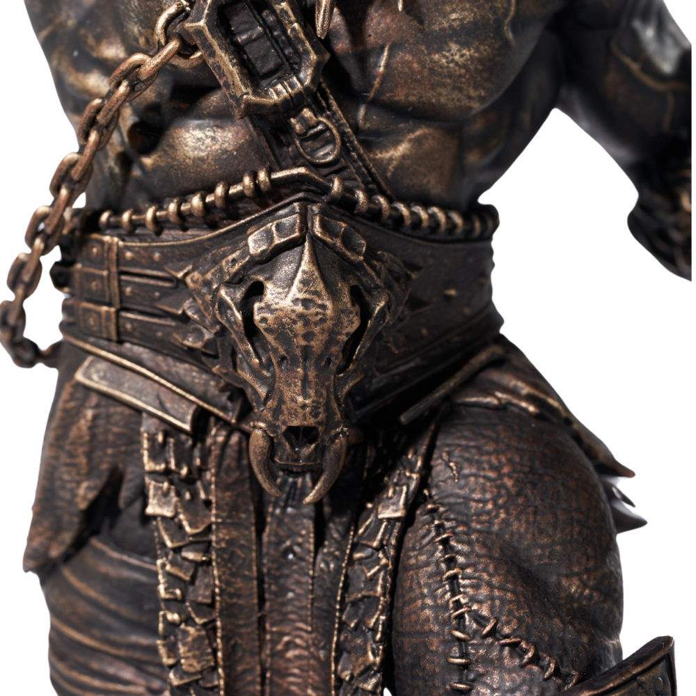 Eine bronzefarbene Statue eines Kriegers in Rüstung mit Ketten und einem Totenkopf-Detail.