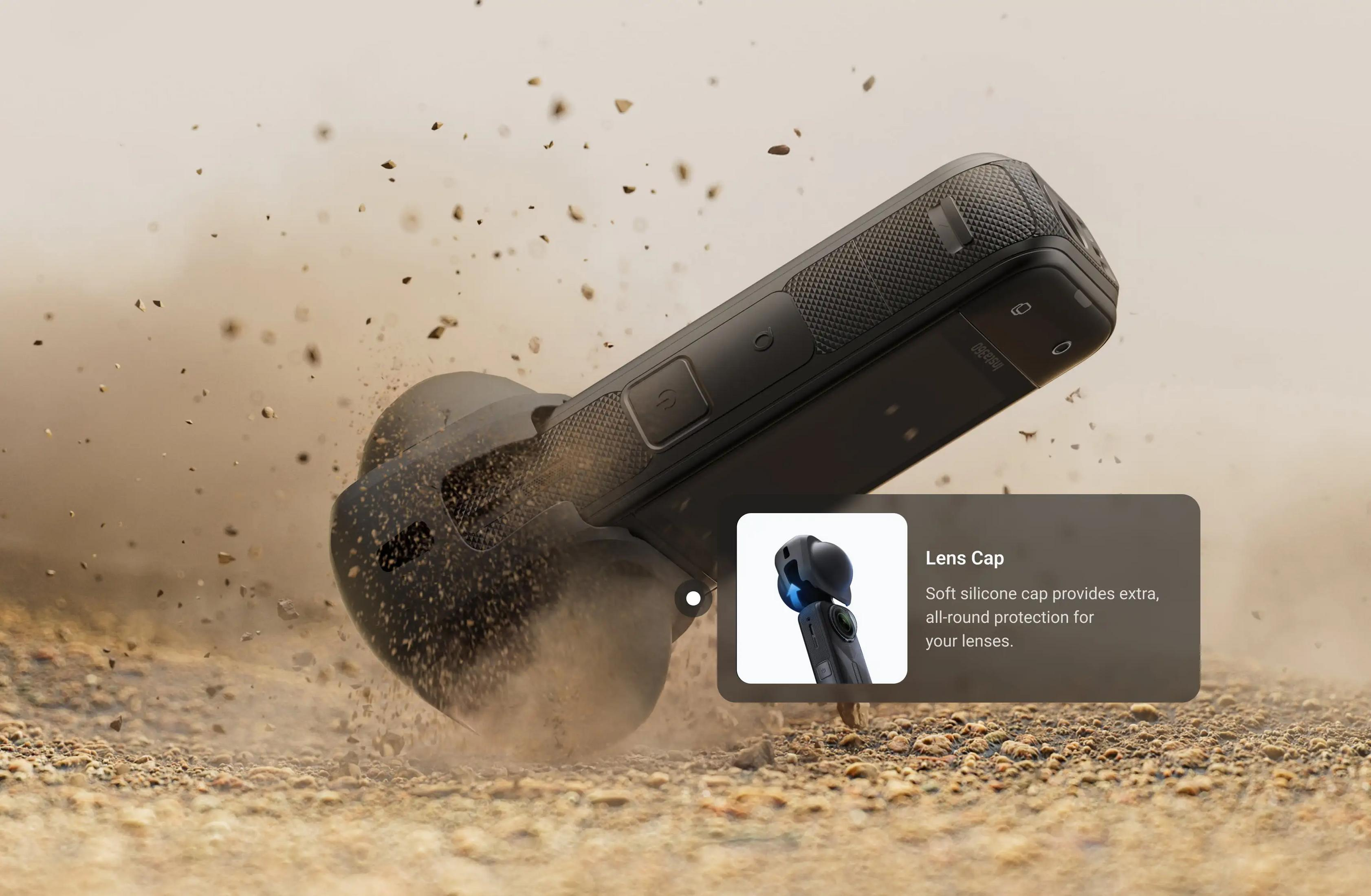 Een zwarte camera valt in het zand, met een lens en een tekstvak.