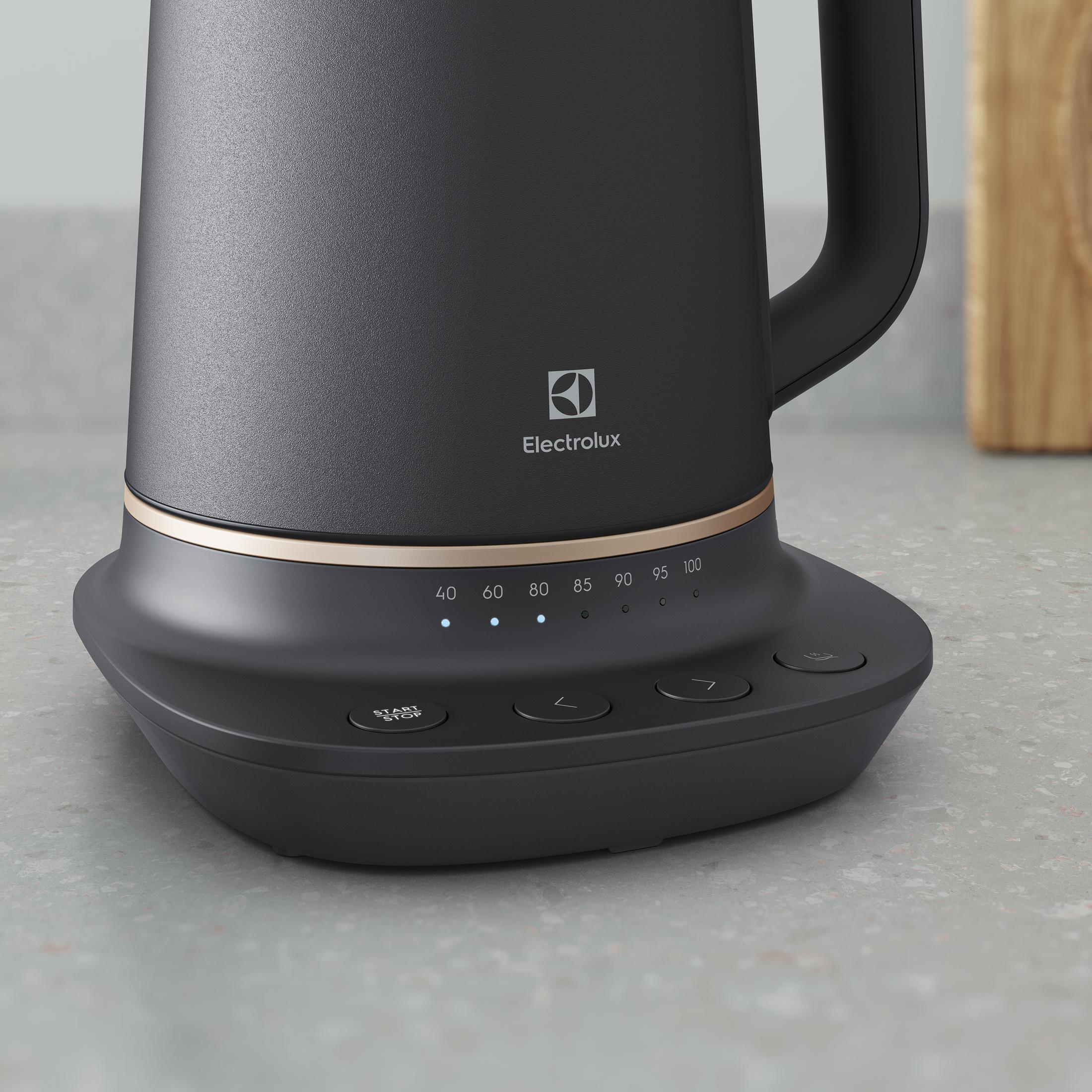 Czajnik elektryczny czarny z wyświetlaczem temperatury i przyciskami na kamiennym blacie.