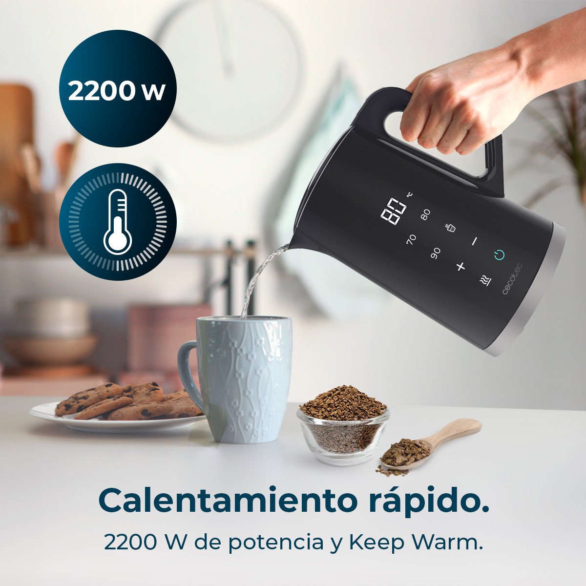 Un bollitore nero versa acqua in una tazza. Biscotti e caffè sono vicini.
