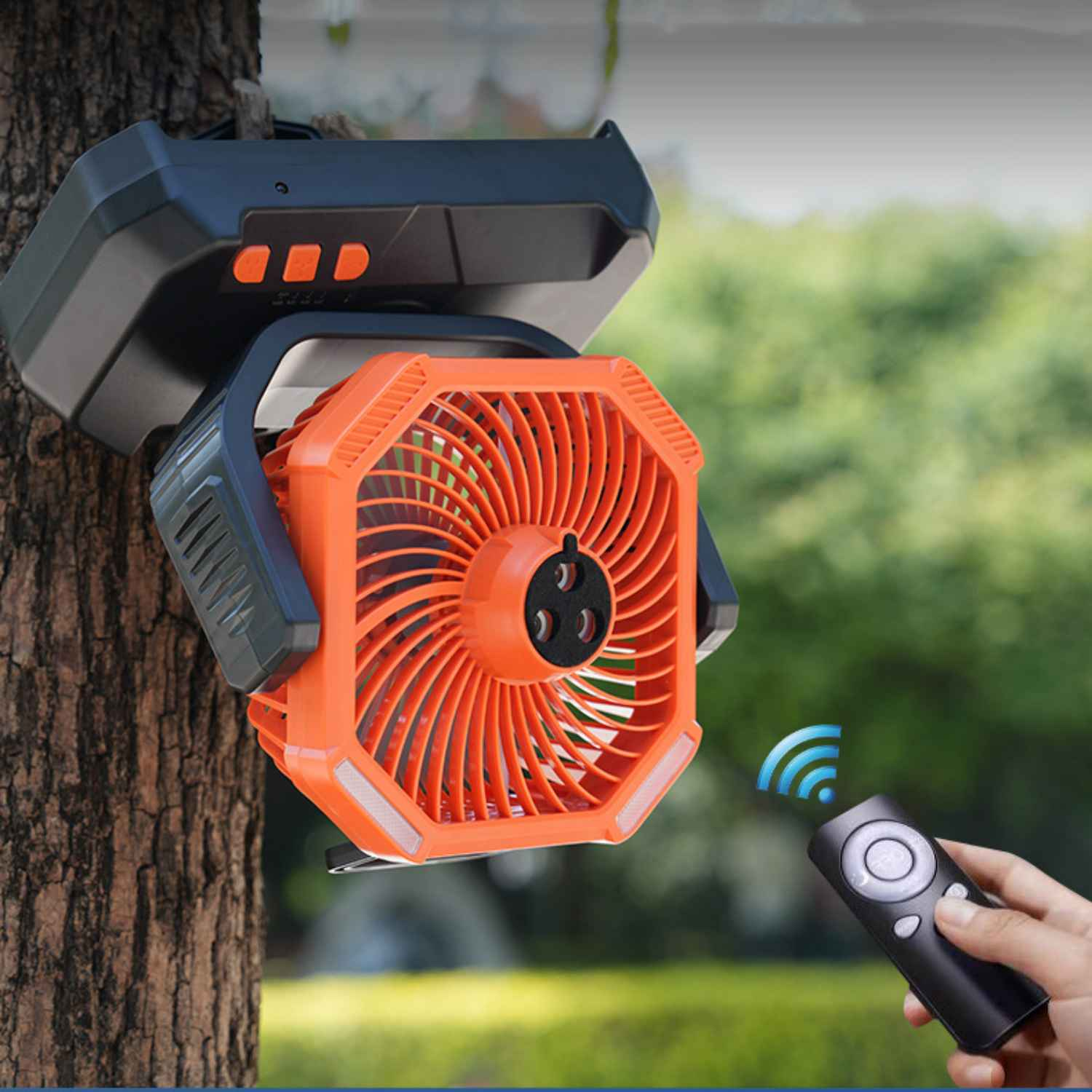 Ein orangefarbener Lüfter mit Fernbedienung, der an einem Baum hängt.