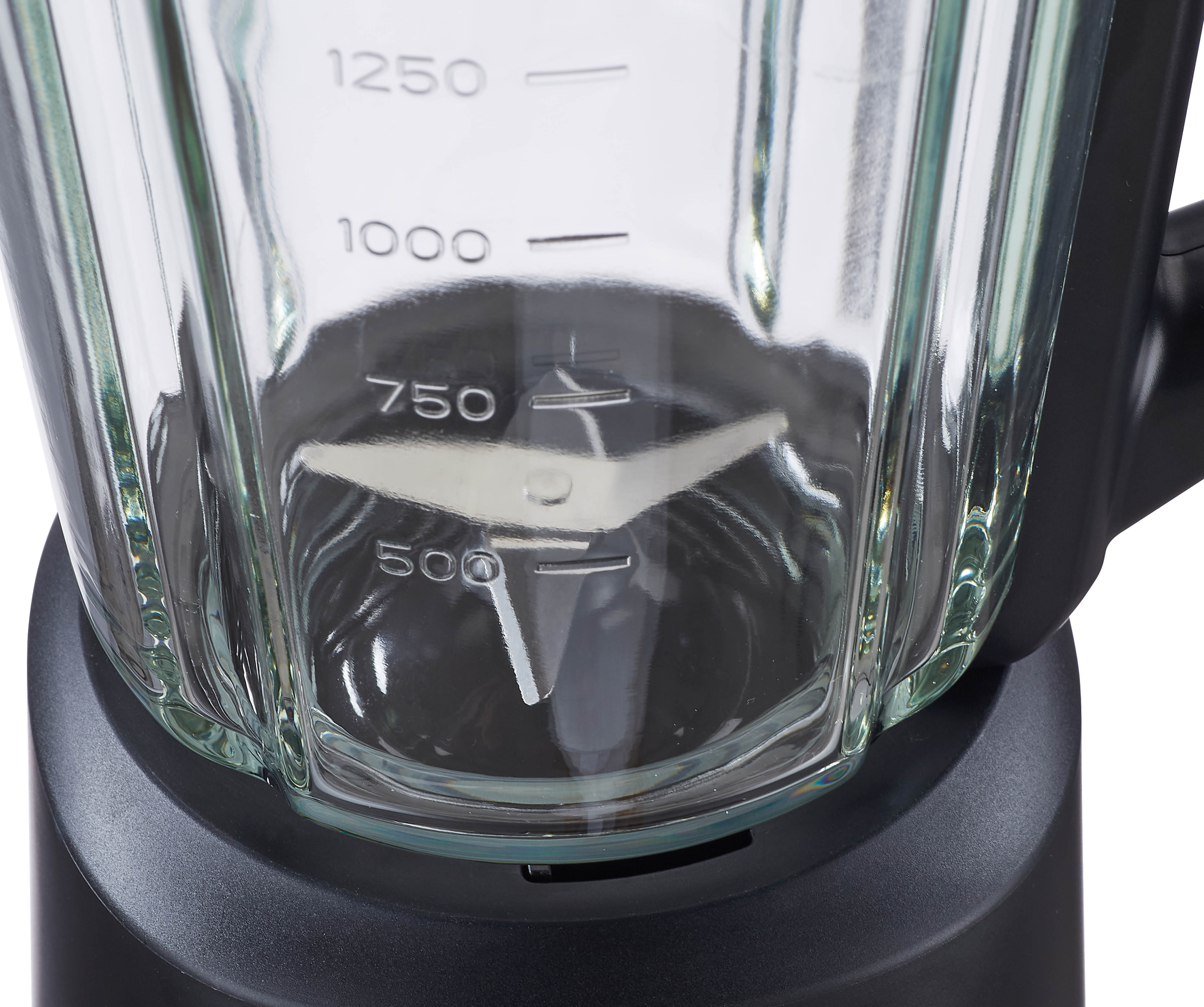 Close-up of a glass blender jar with measurement markings and blades.