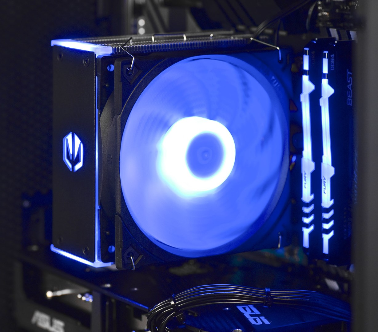 Chłodnica CPU komputera z niebieskimi światłami LED i modułami RAM.