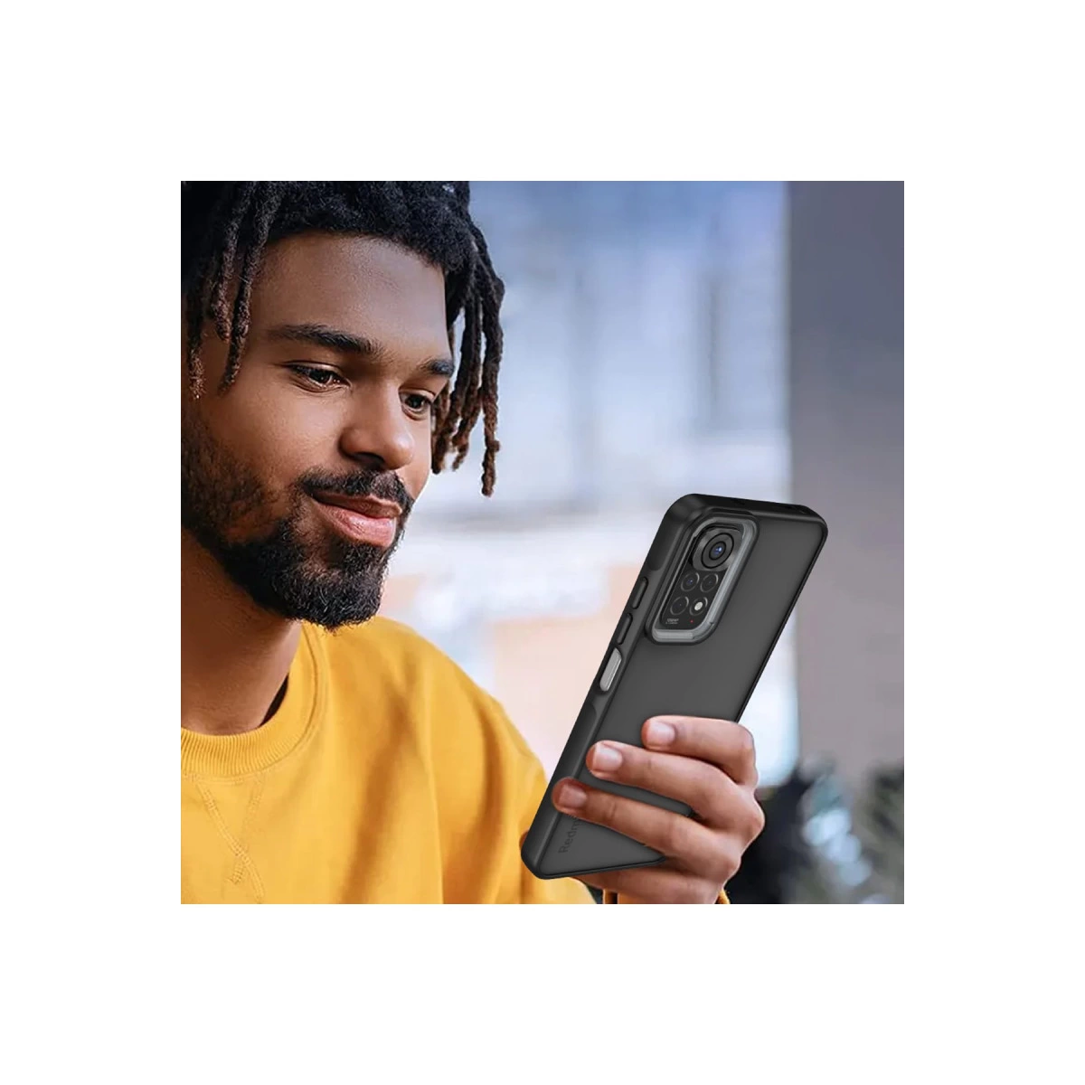 Dreadlocklı bir adam dört kameralı siyah bir akıllı telefon tutuyor.