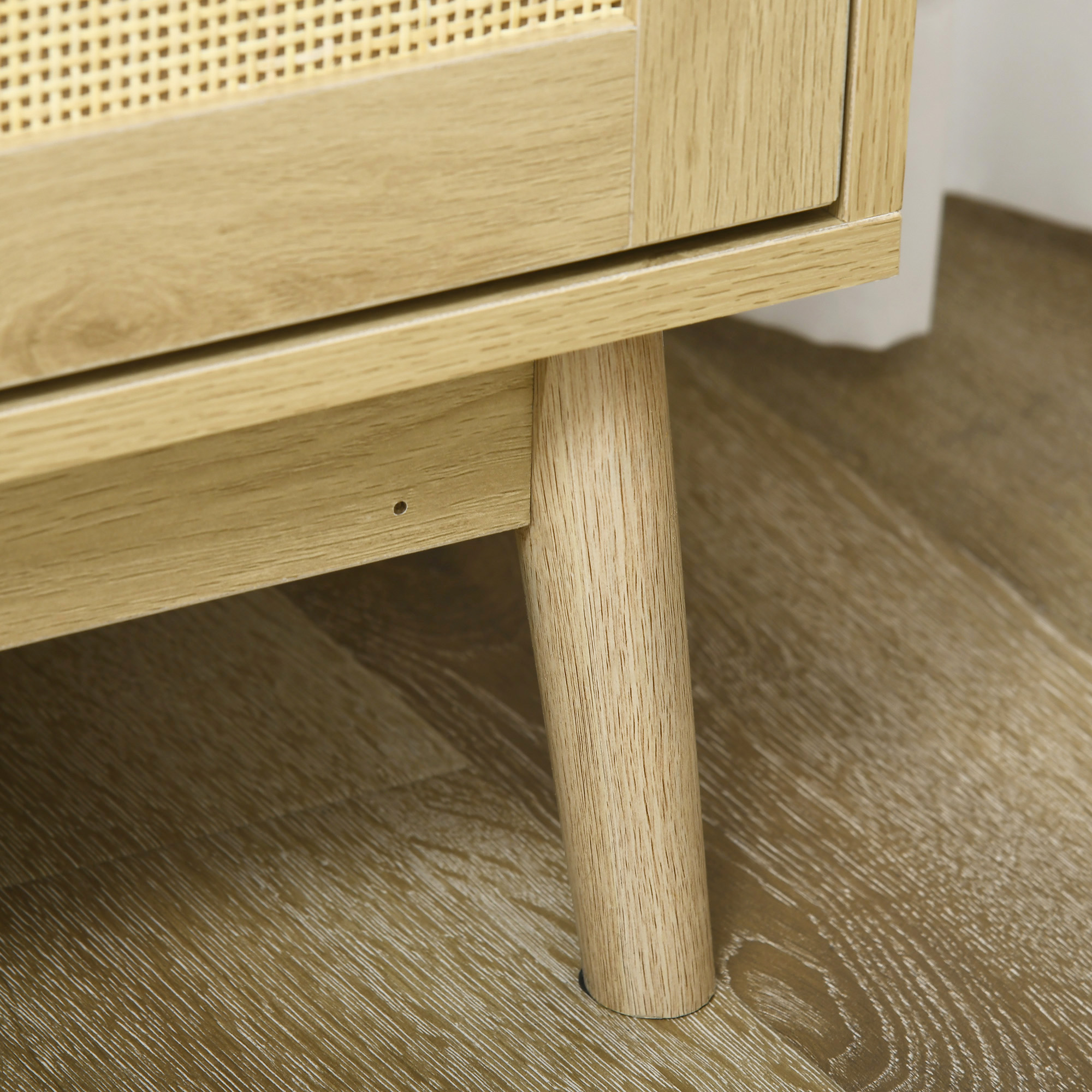 Pata de mueble de madera sobre suelo de madera. Vista cercana.