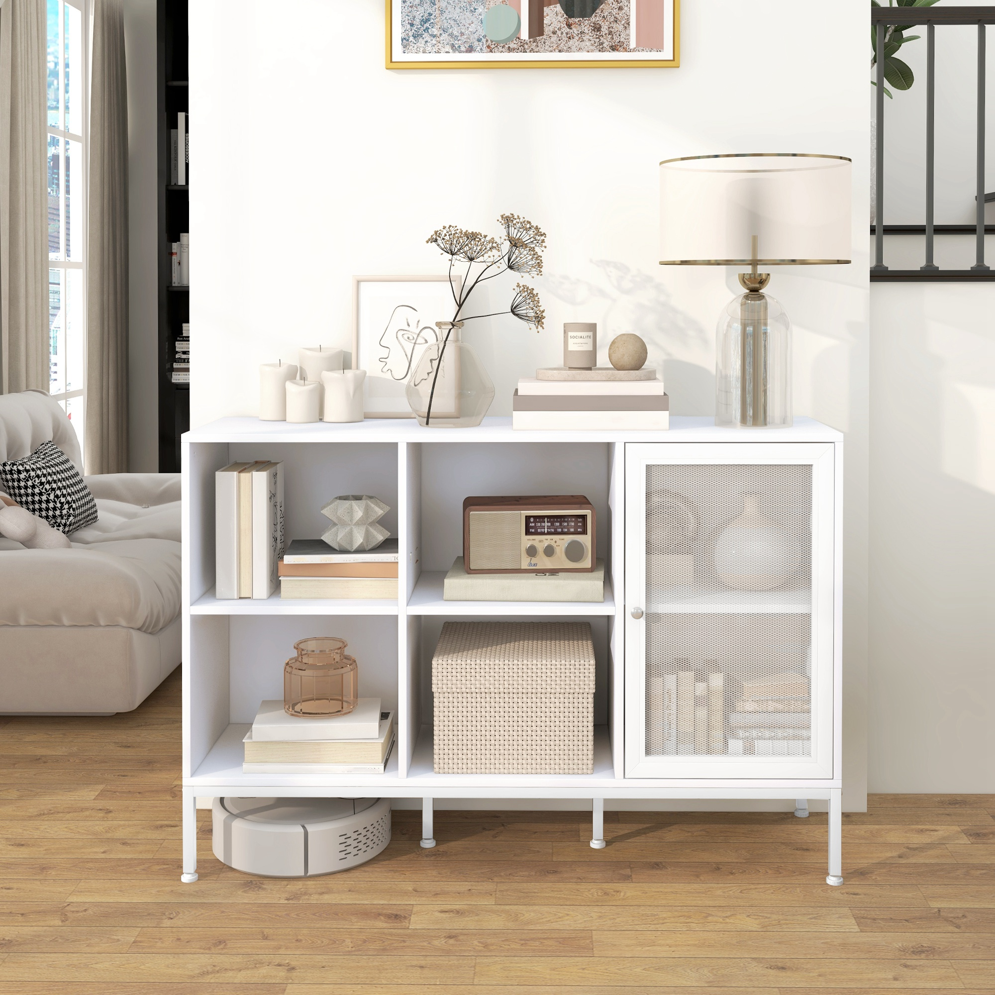 Un estante blanco con libros, radio y objetos decorativos sobre suelo de madera.