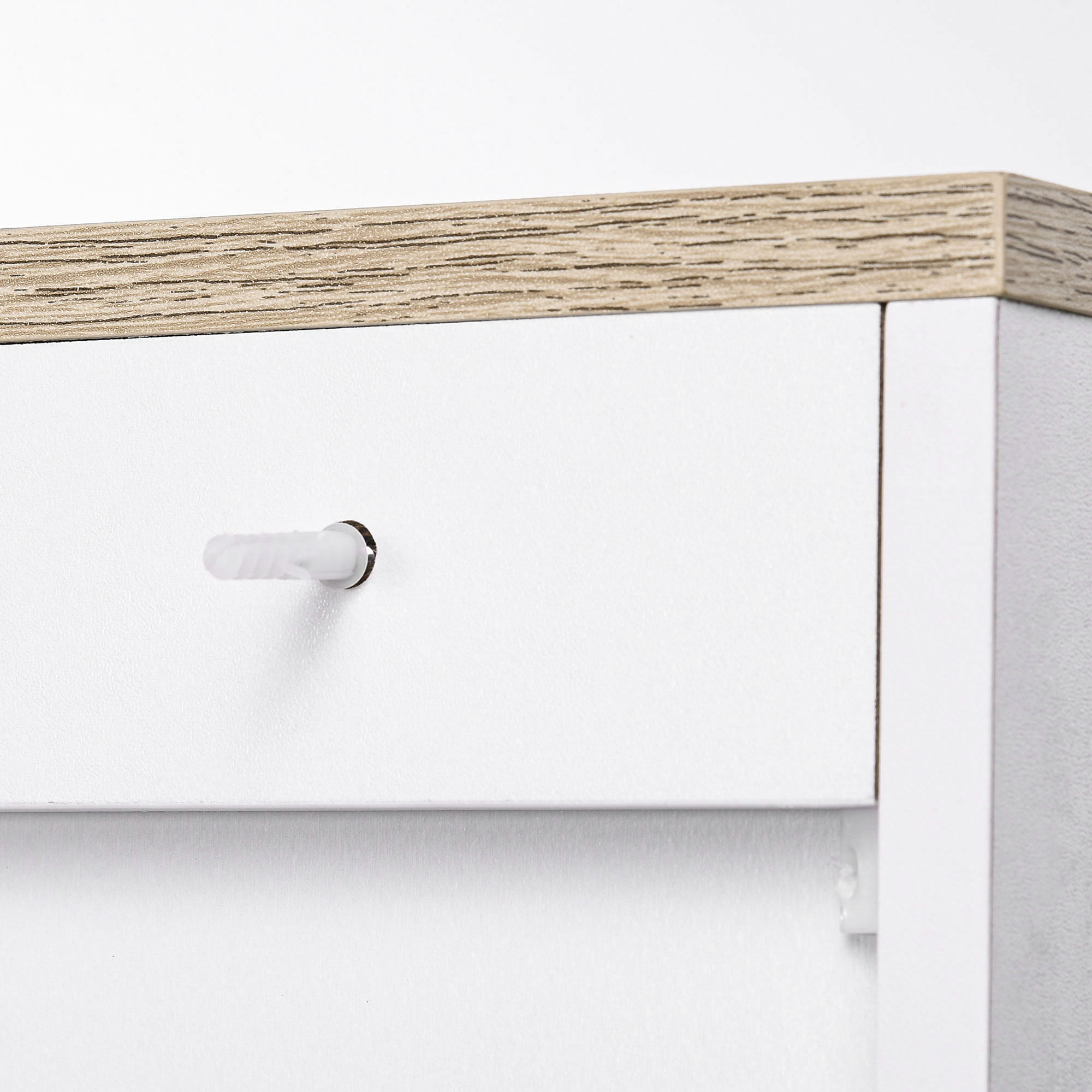 Borde superior de veta de madera sobre cajón blanco con taco.