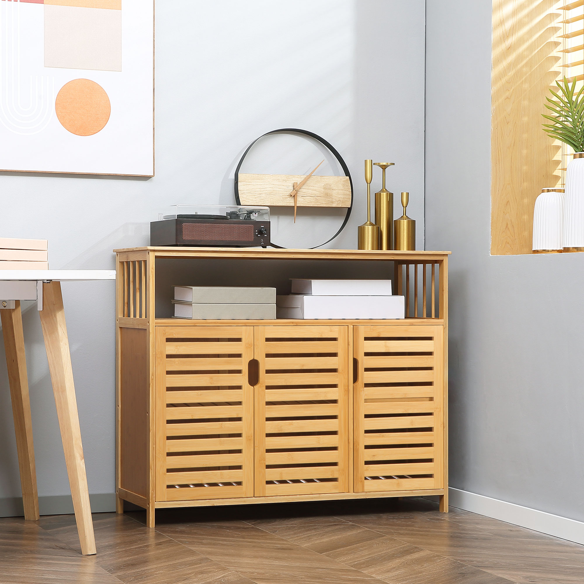 Un mueble de bambú con tres puertas junto a un escritorio. Libros encima.