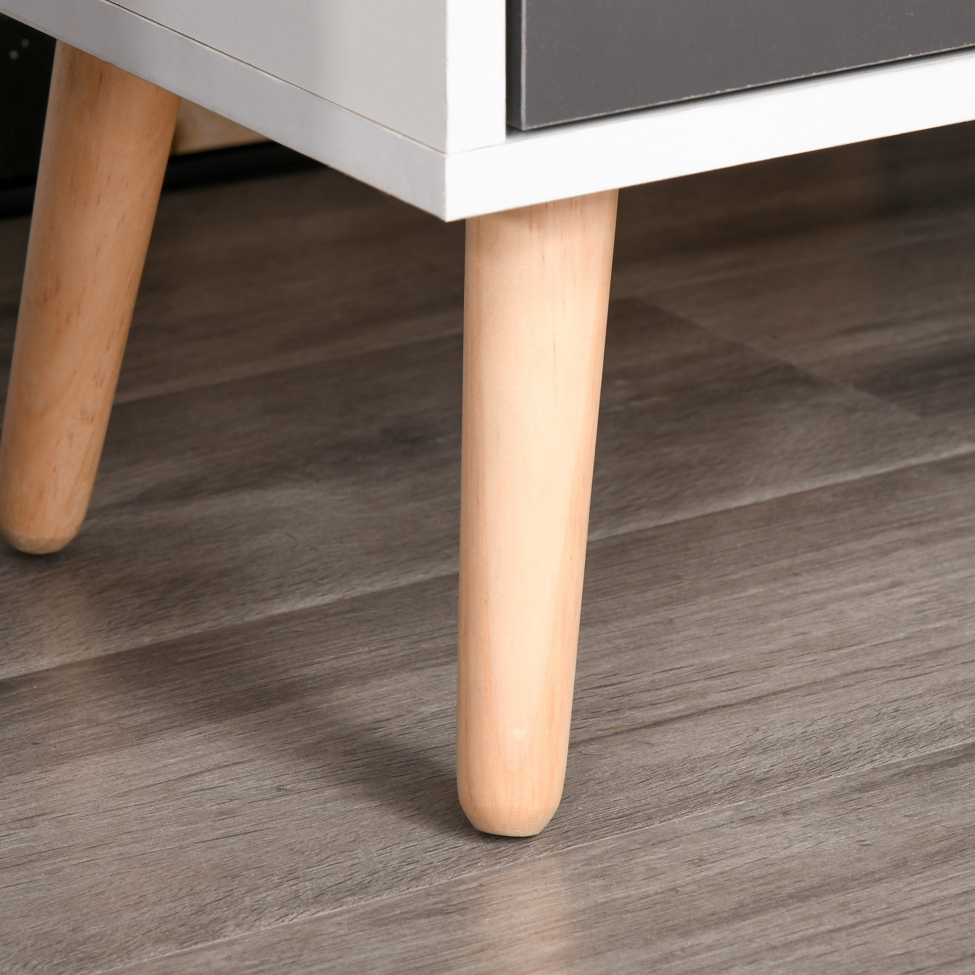 Frentes de muebles blancos y grises sobre tres patas de madera.