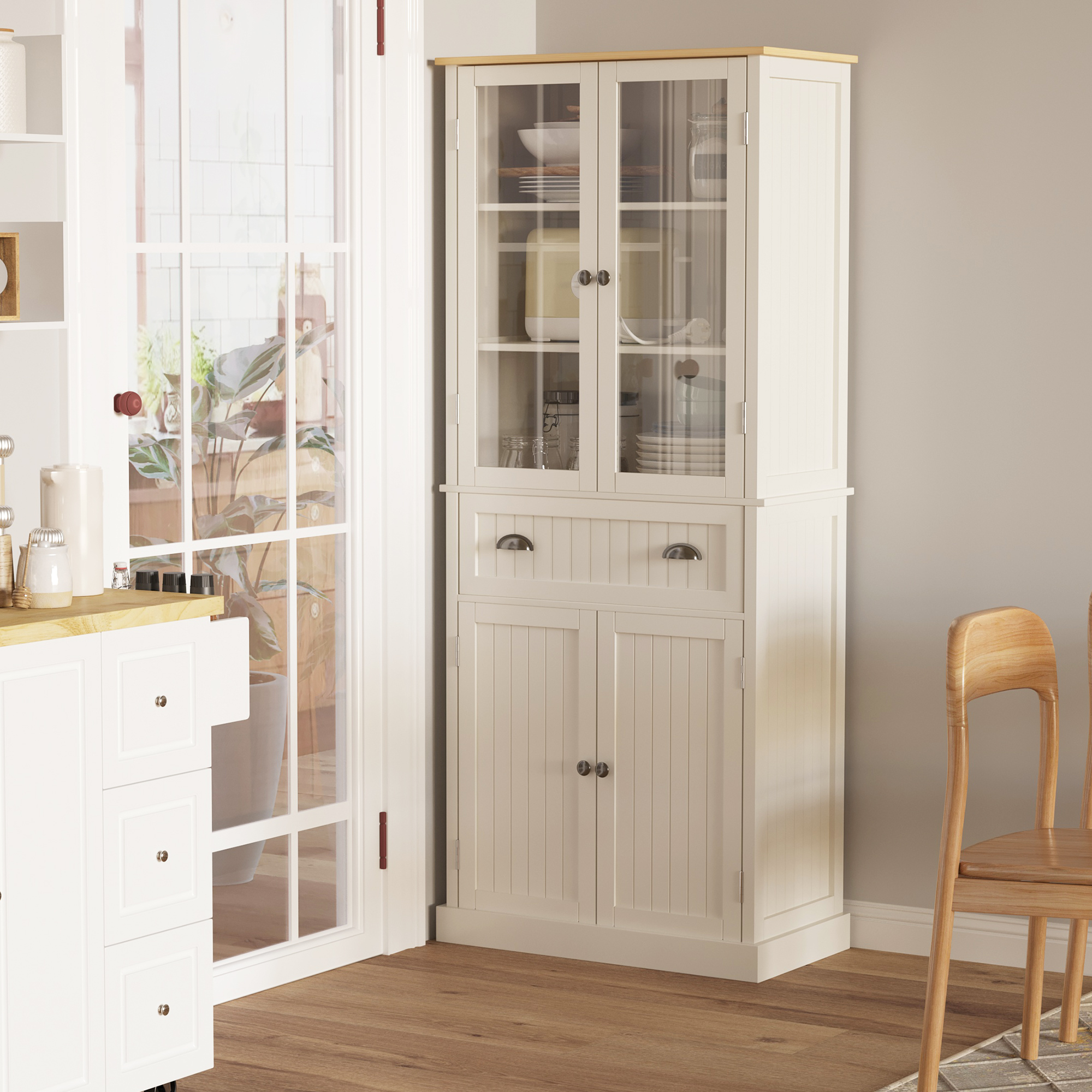 Una vitrina de cocina blanca con puertas de cristal está junto a una puerta con plantas detrás.