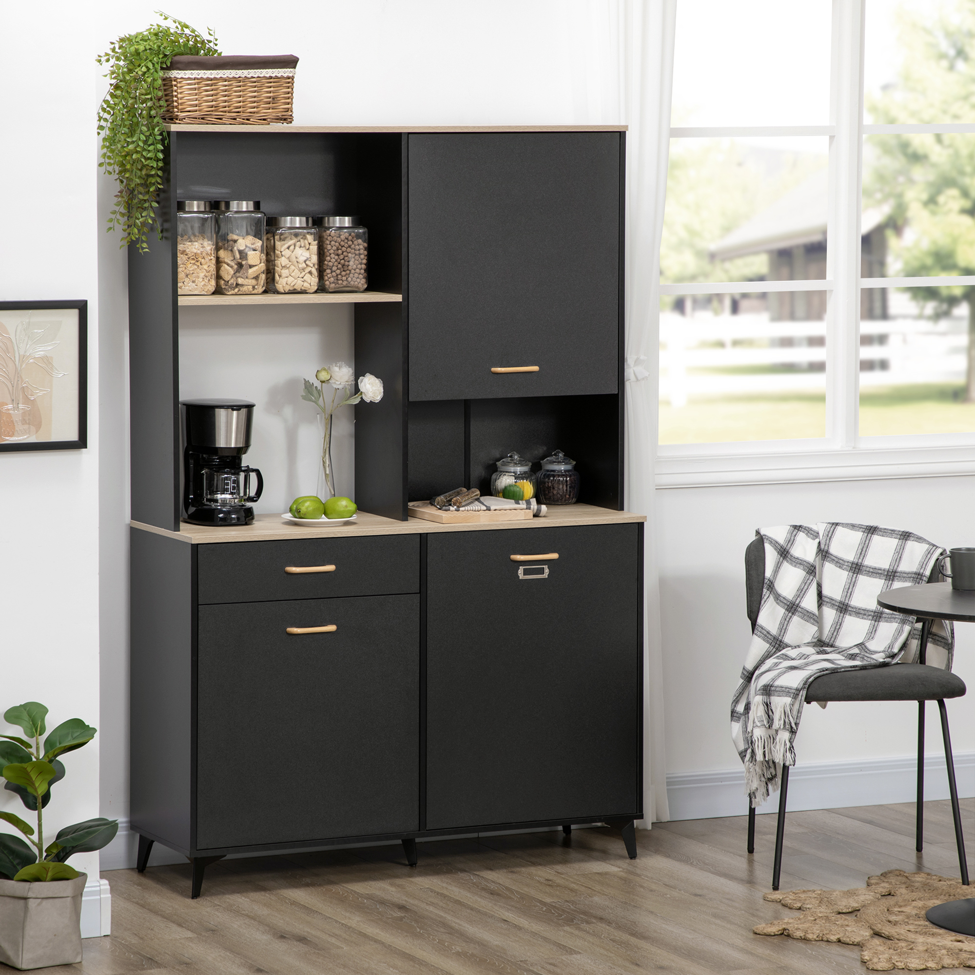 Un aparador de cocina negro con detalles de madera, lleno de suministros y electrodomésticos.