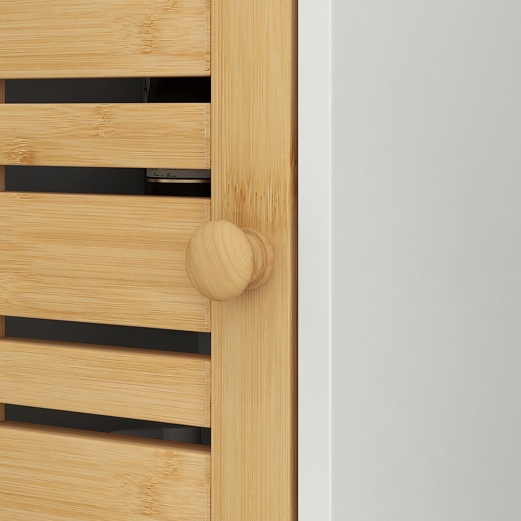 Un pomo redondo de madera en una estantería de bambú con lamas horizontales. A la izquierda, un área blanca.