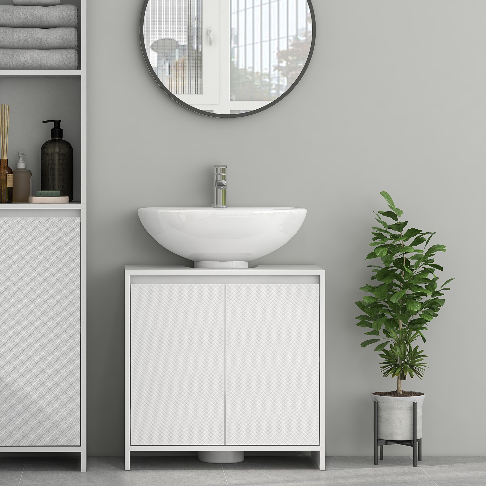 Baño moderno con lavabo blanco, tocador y toallas. Una planta en maceta a la derecha.