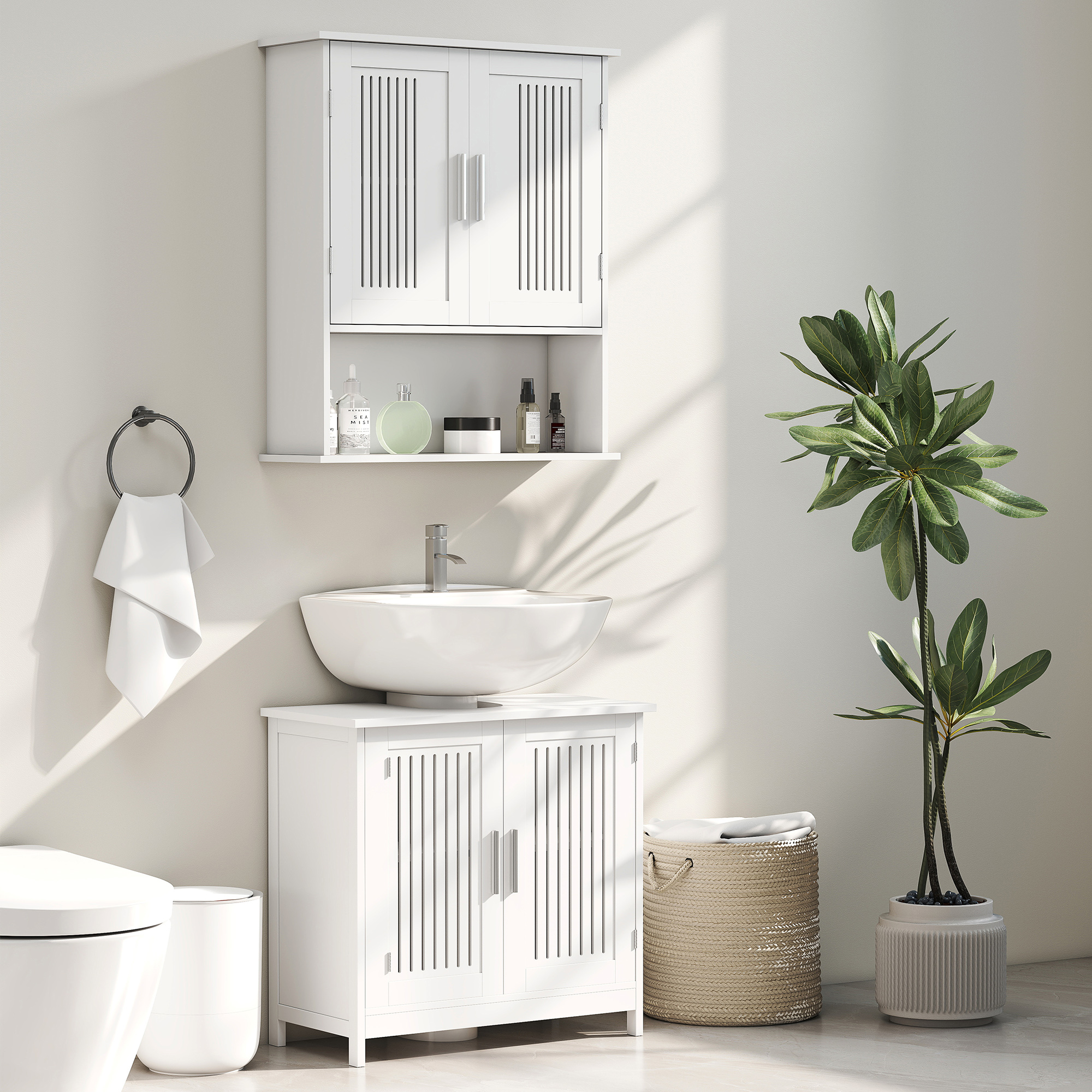 Un baño blanco con inodoro, lavabo, mueble y planta.