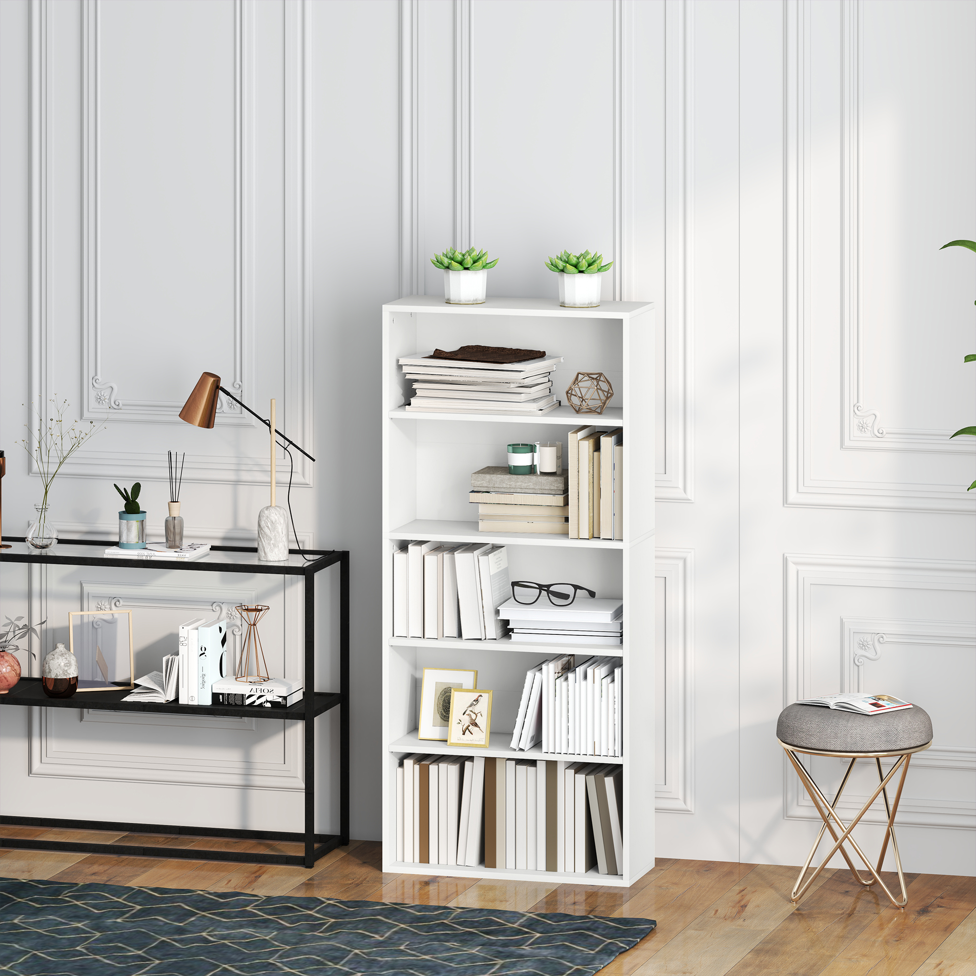 Una estantería blanca con libros, plantas y decoraciones junto a un mueble negro.