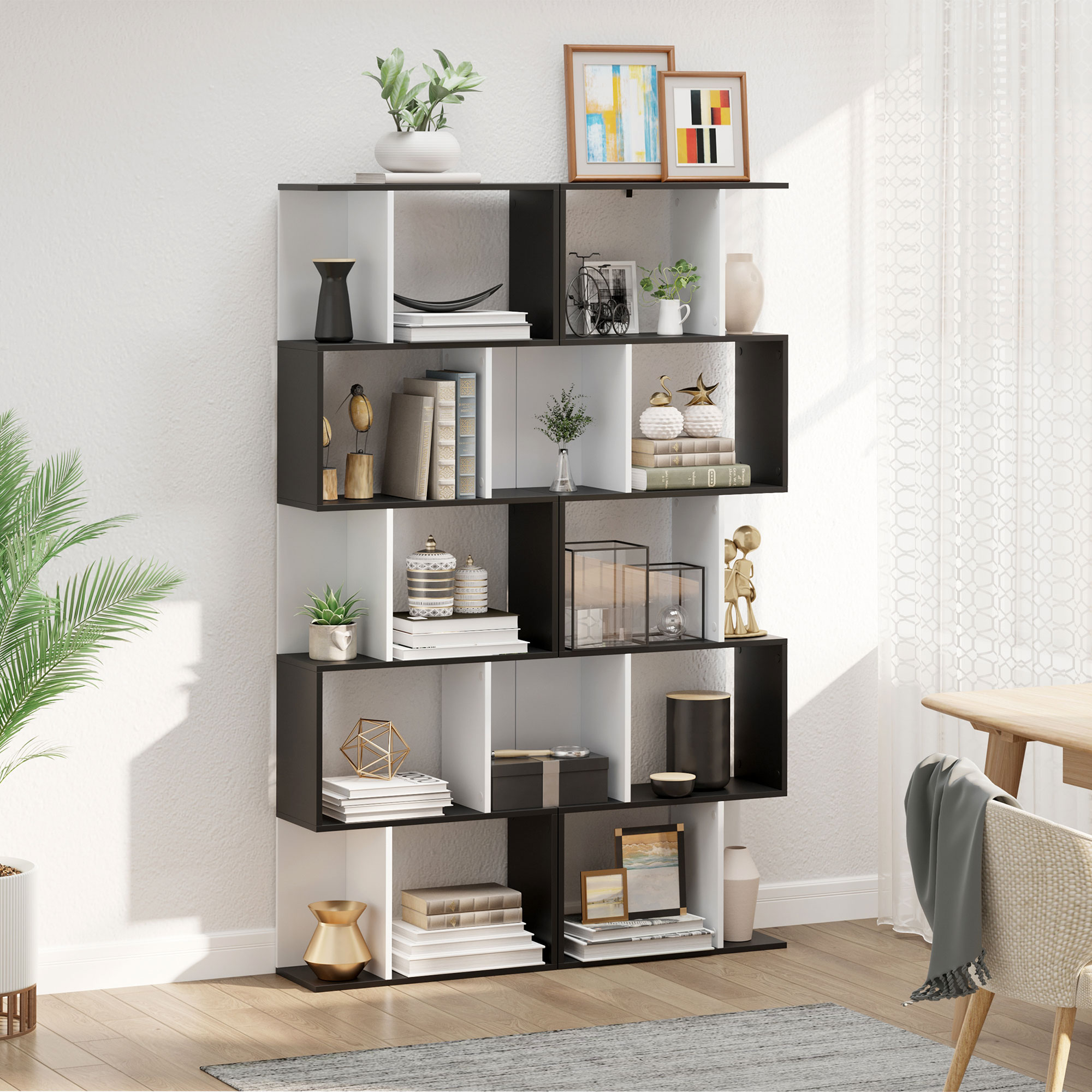 Un estante blanco y negro con libros y objetos decorativos.