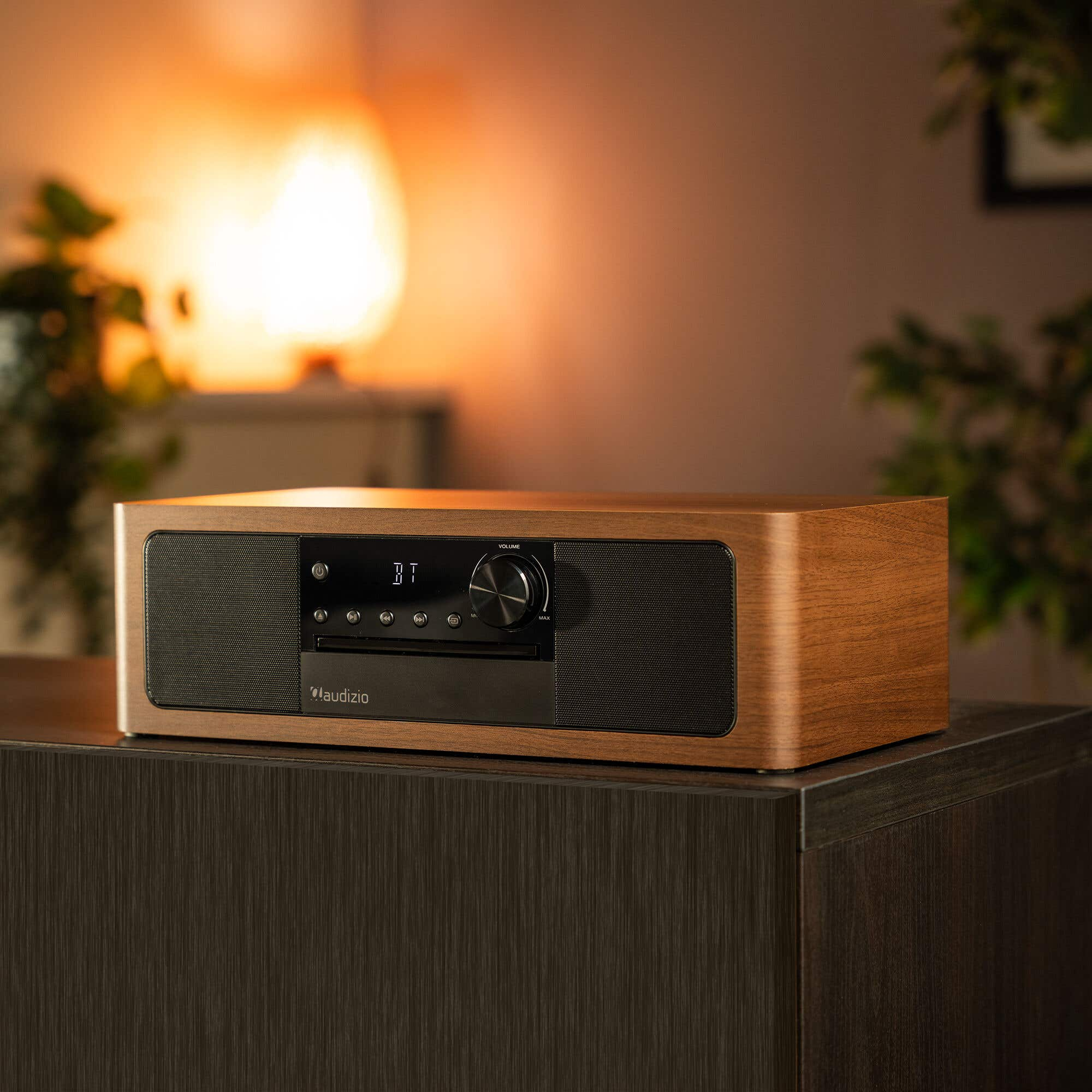 A wooden radio with CD player and speakers sits on a dark cabinet.
