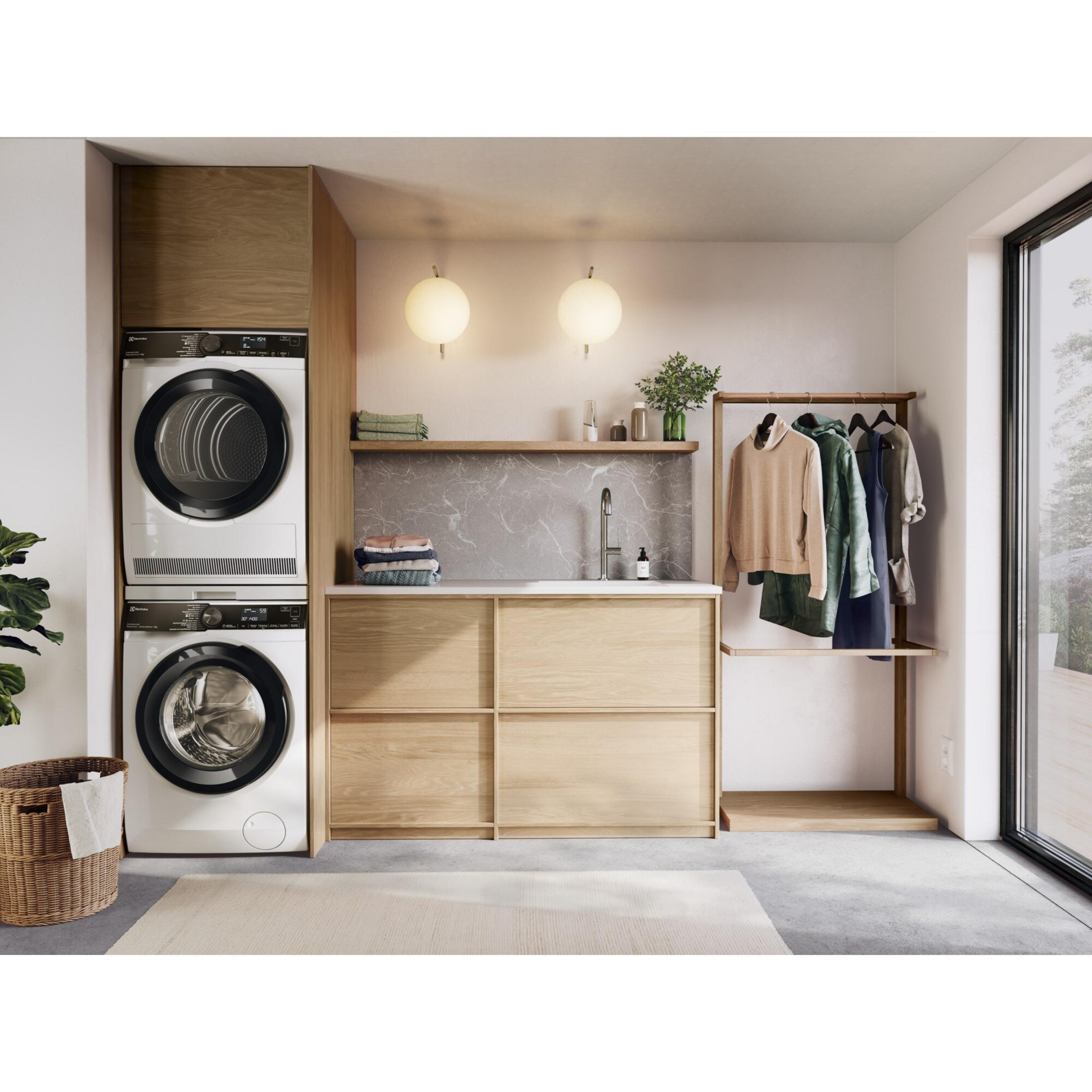 Ein modernes Waschkücheninterieur mit Waschmaschine und Trockner übereinander.