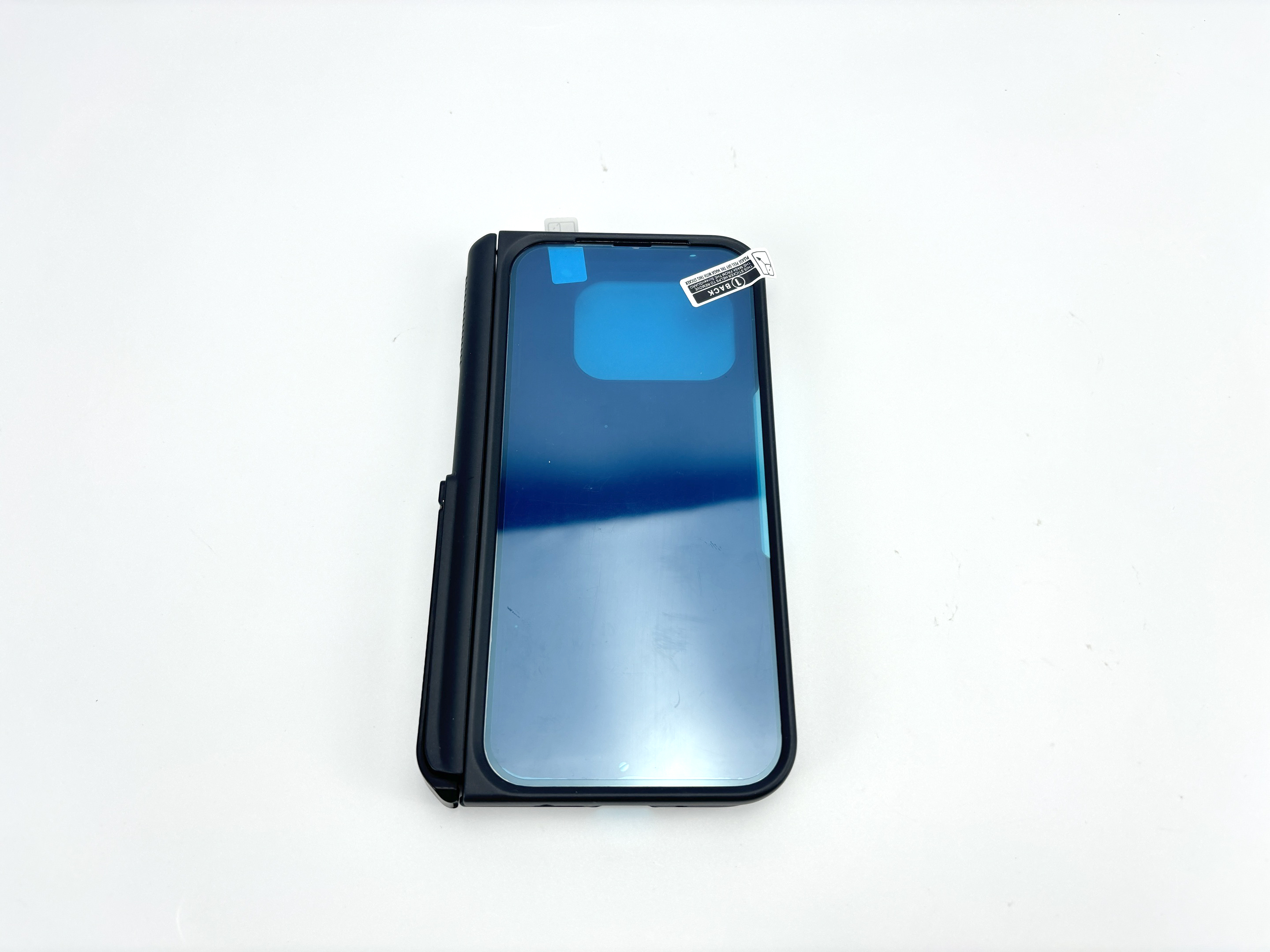 Ein schwarzer Smartphone-Ständer mit blauem Bildschirm und einem Aufkleber.