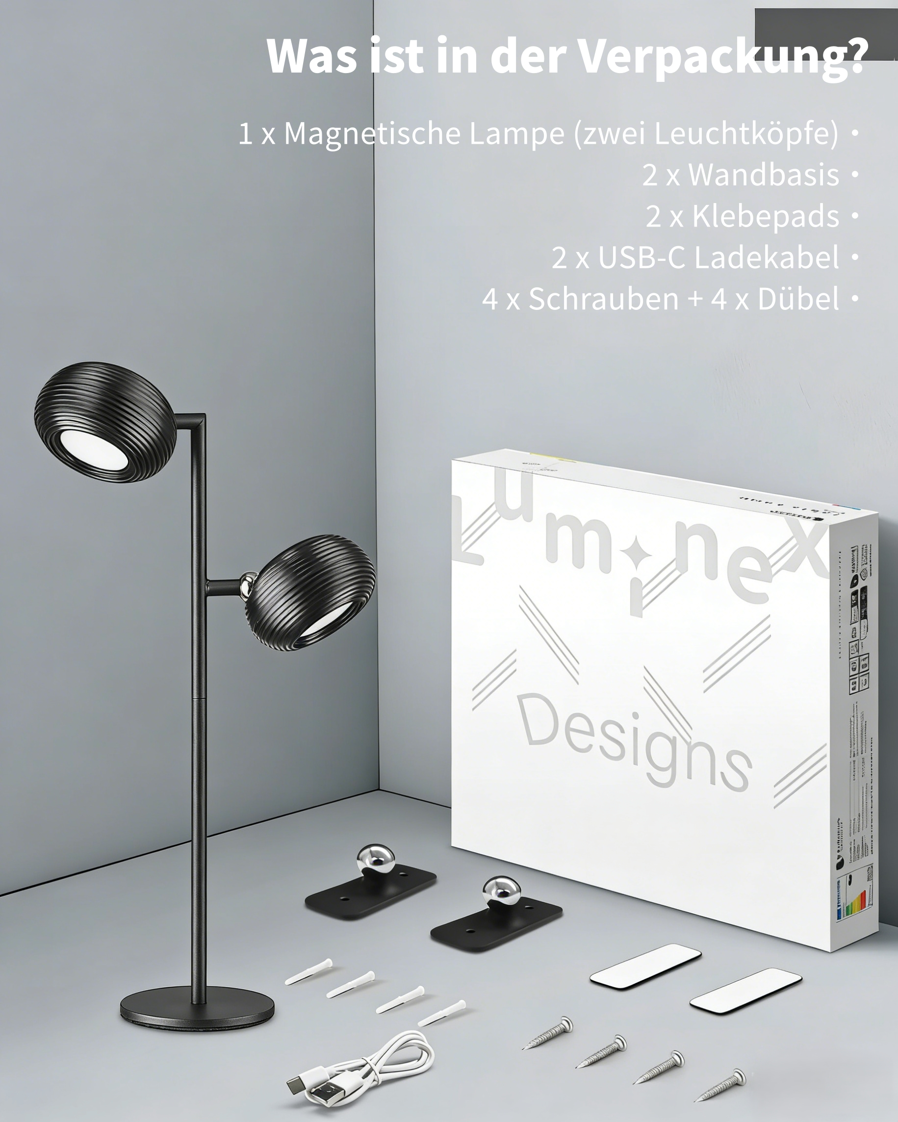 Schwarze Doppelkopflampe mit Zubehör: Wandbasen, Klebepads, Kabel, Schrauben.