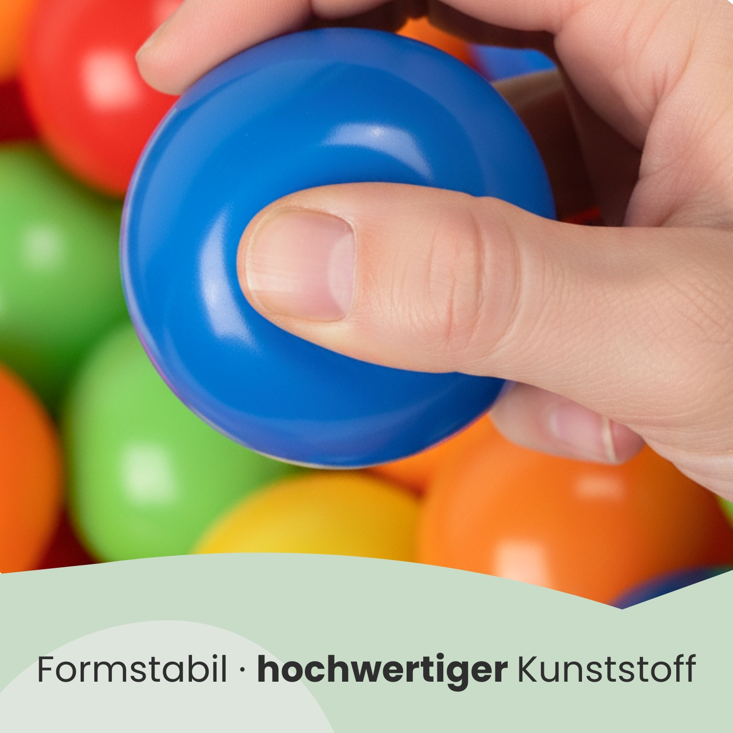 Eine Hand hält einen blauen Ball vor vielen bunten Kugeln.