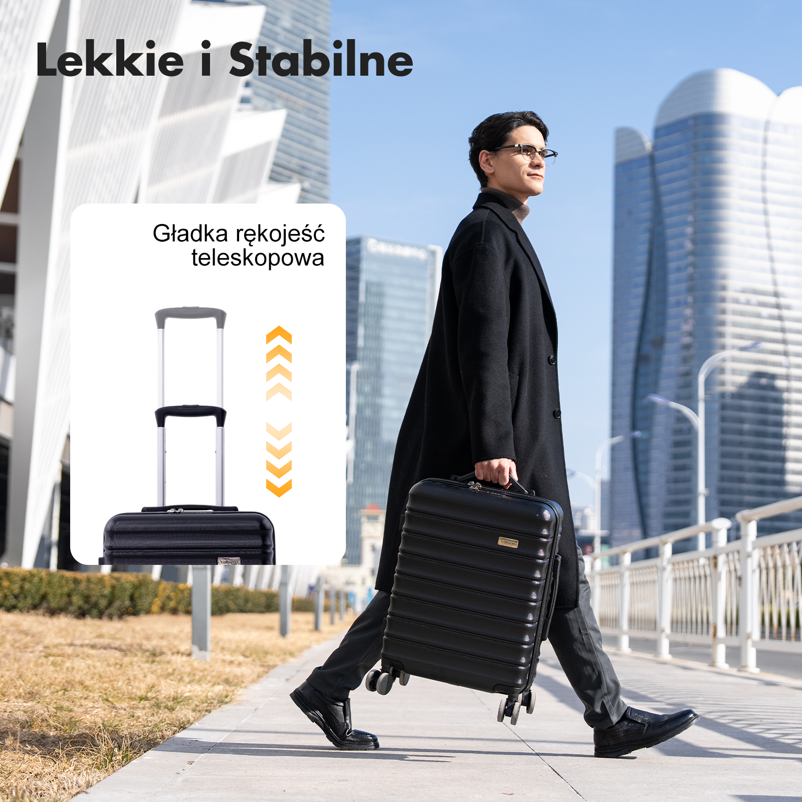 Mężczyzna w czarnym płaszczu i okularach ciągnie czarną walizkę na kółkach po chodniku.