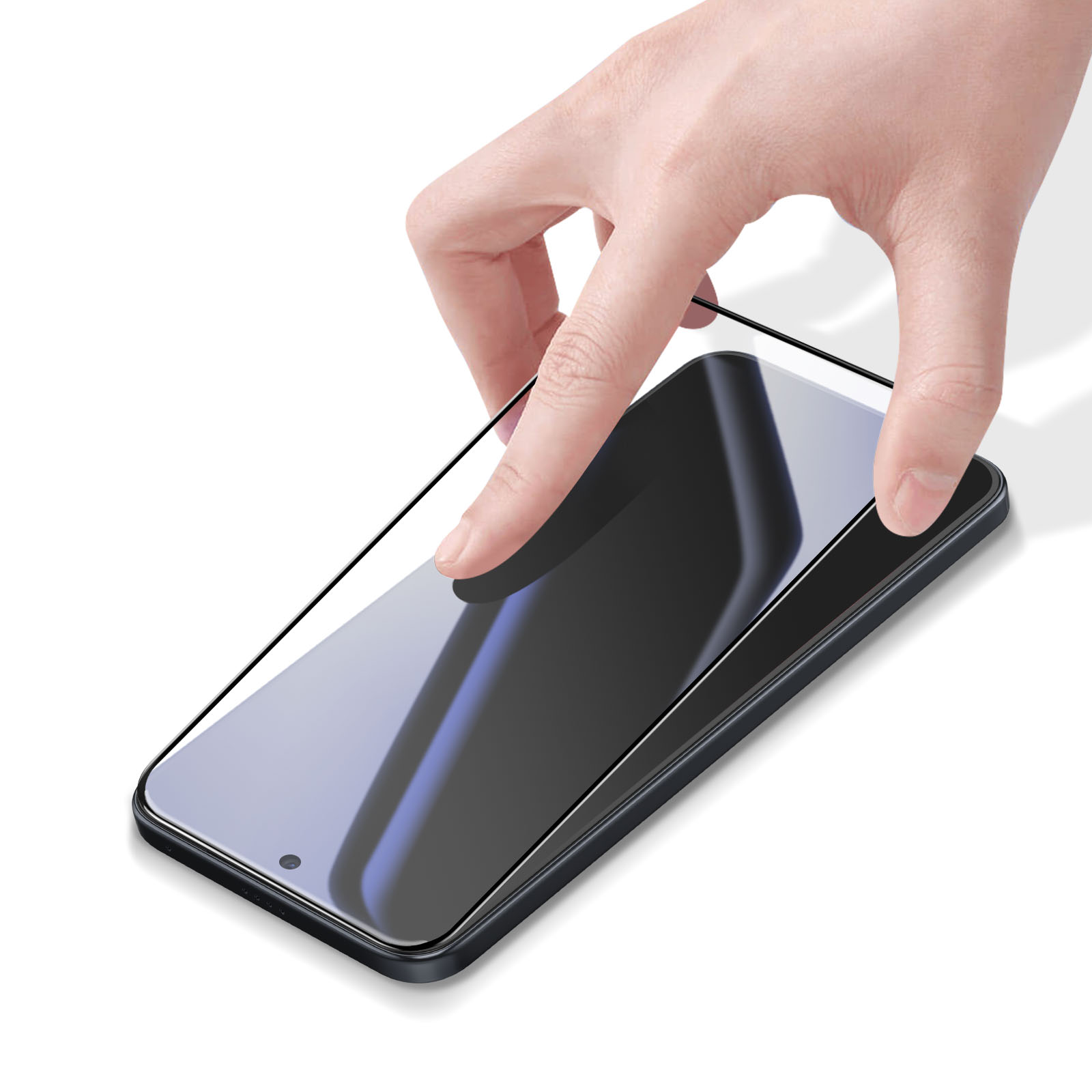 Una mano posiziona una protezione per lo schermo su uno smartphone scuro.